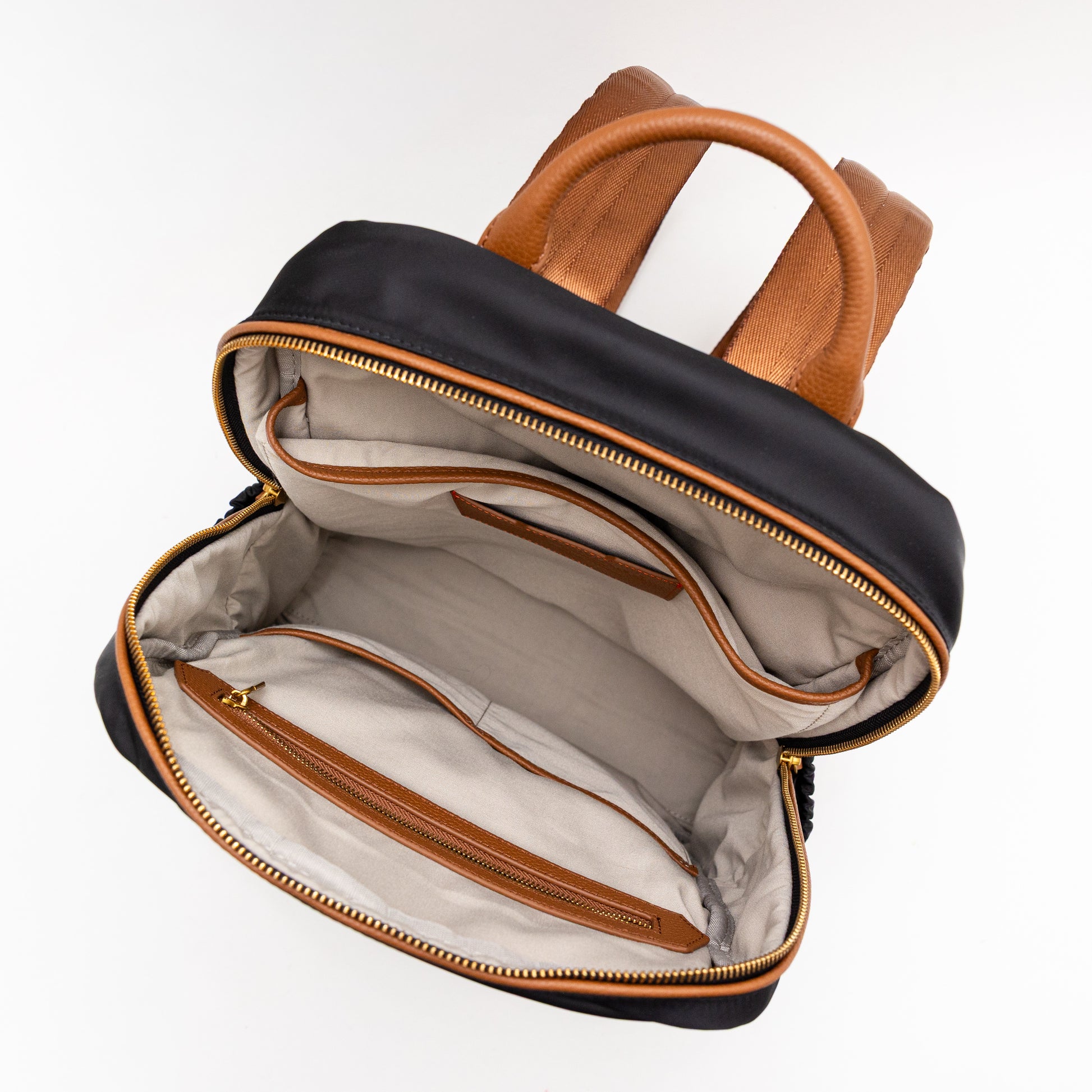 Open black and brown leather backpack on a white background