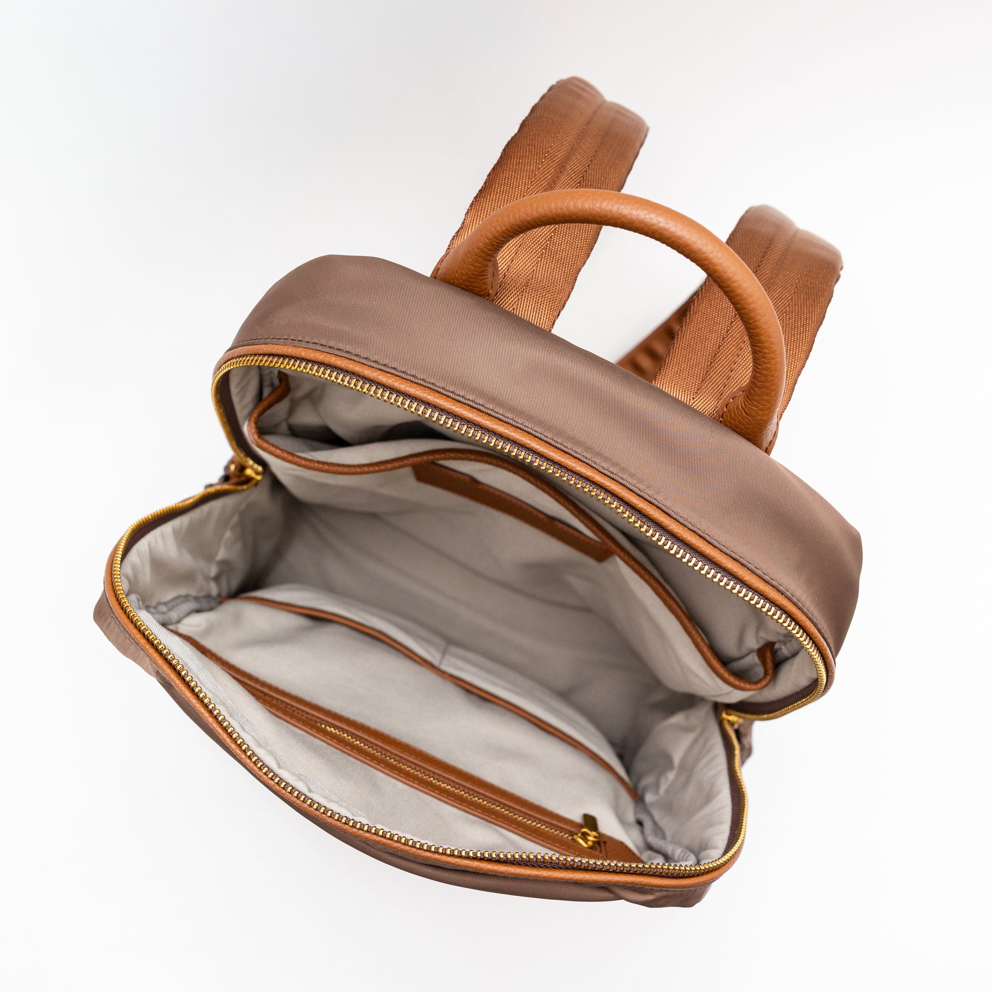 Brown leather backpack with gold zipper on a white background