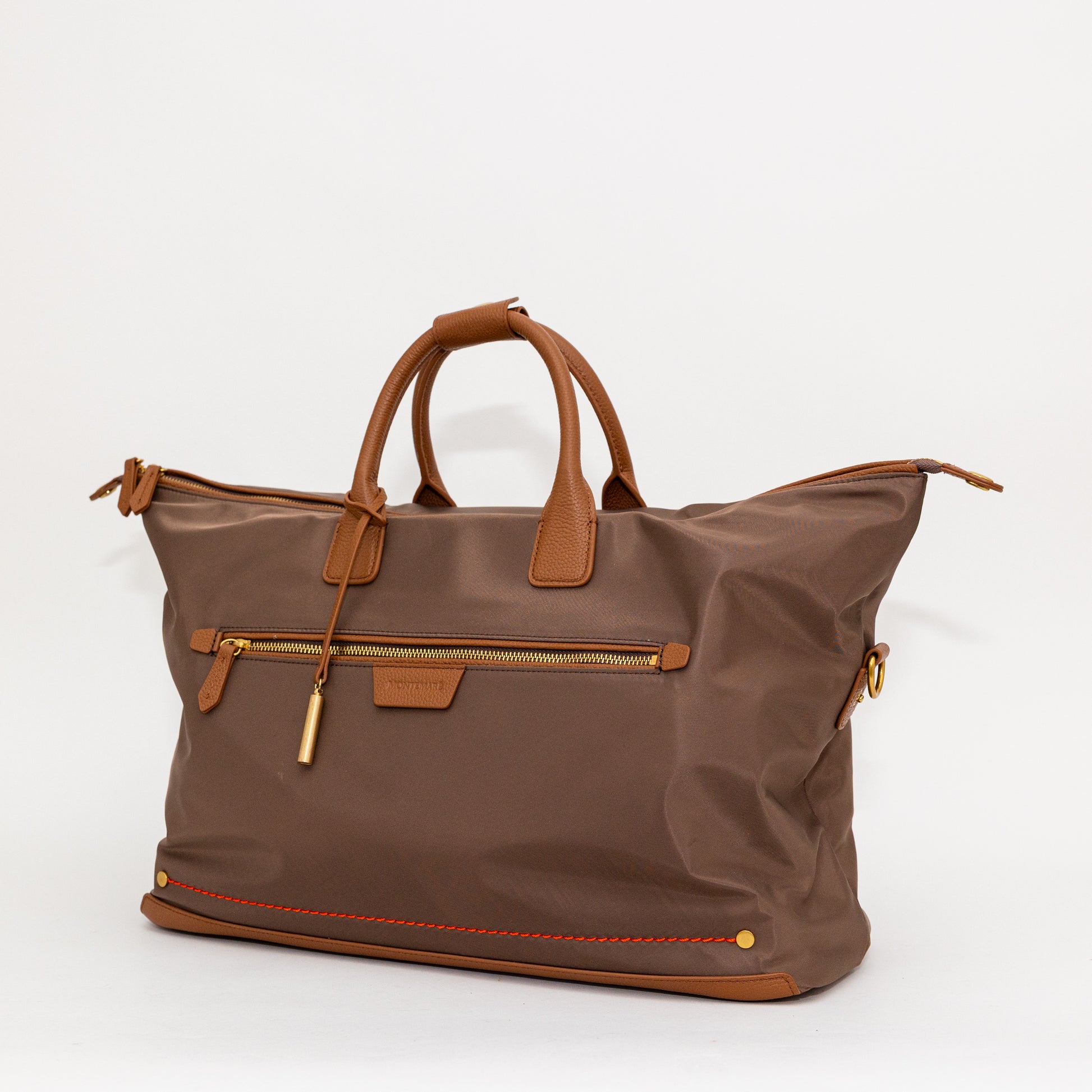 Brown carry on bag with leather accents on a white background