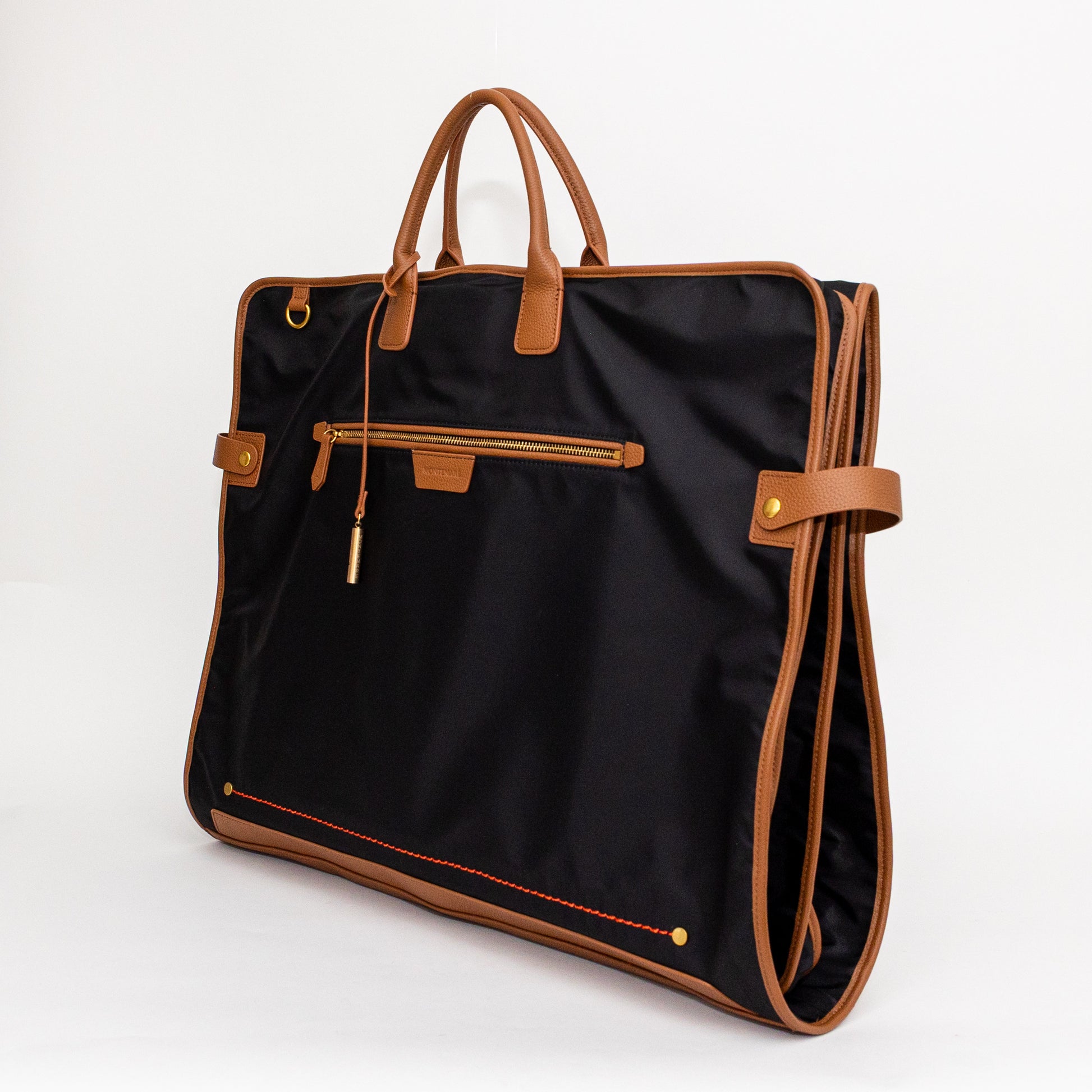Black garment bag with brown leather straps and trim on a white background