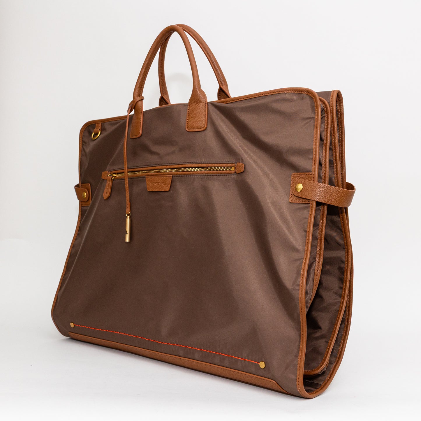 Brown garment bag with leather handles and trim on a white background