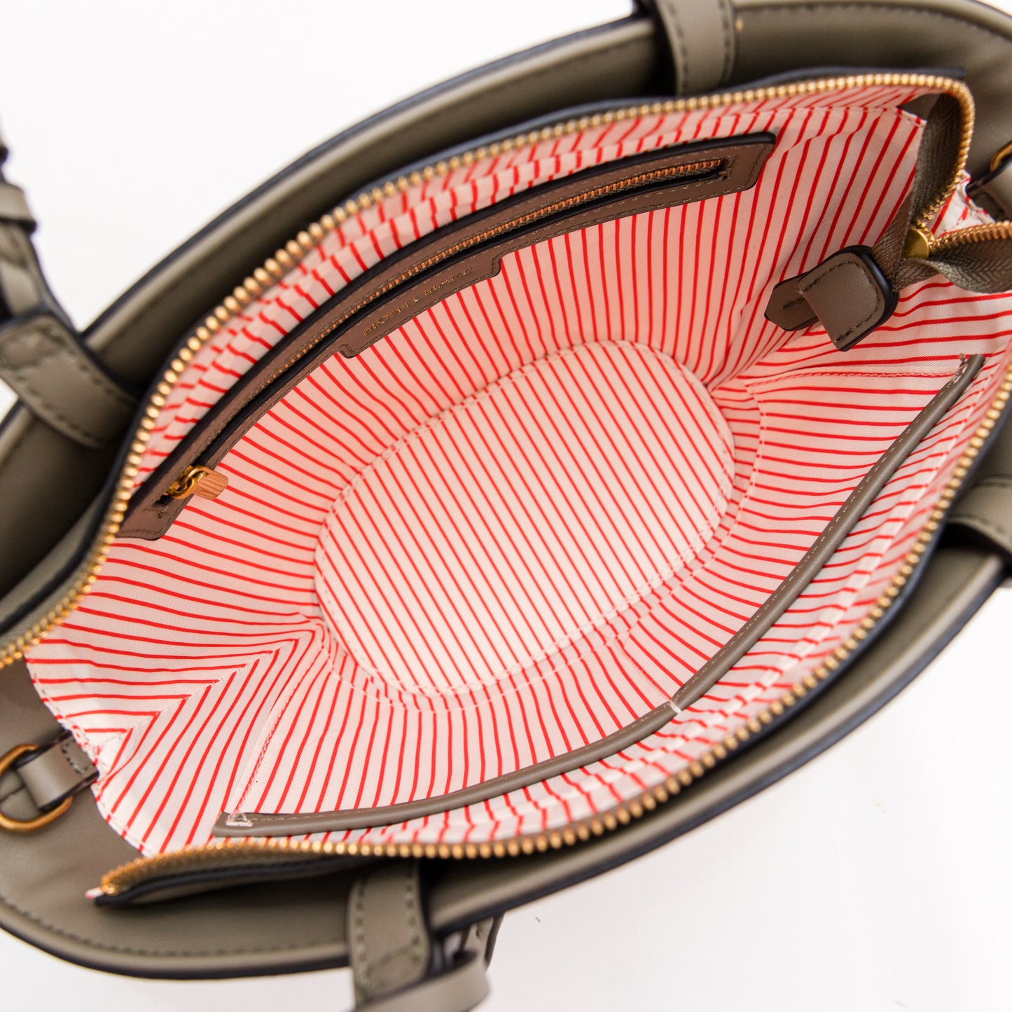 Open olive colored handbag with red and white striped lining on a white background