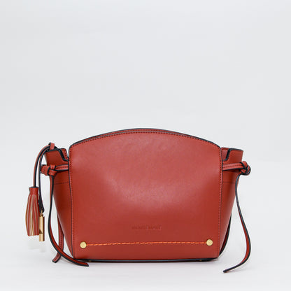 Terracotta leather handbag with a strap on a white background