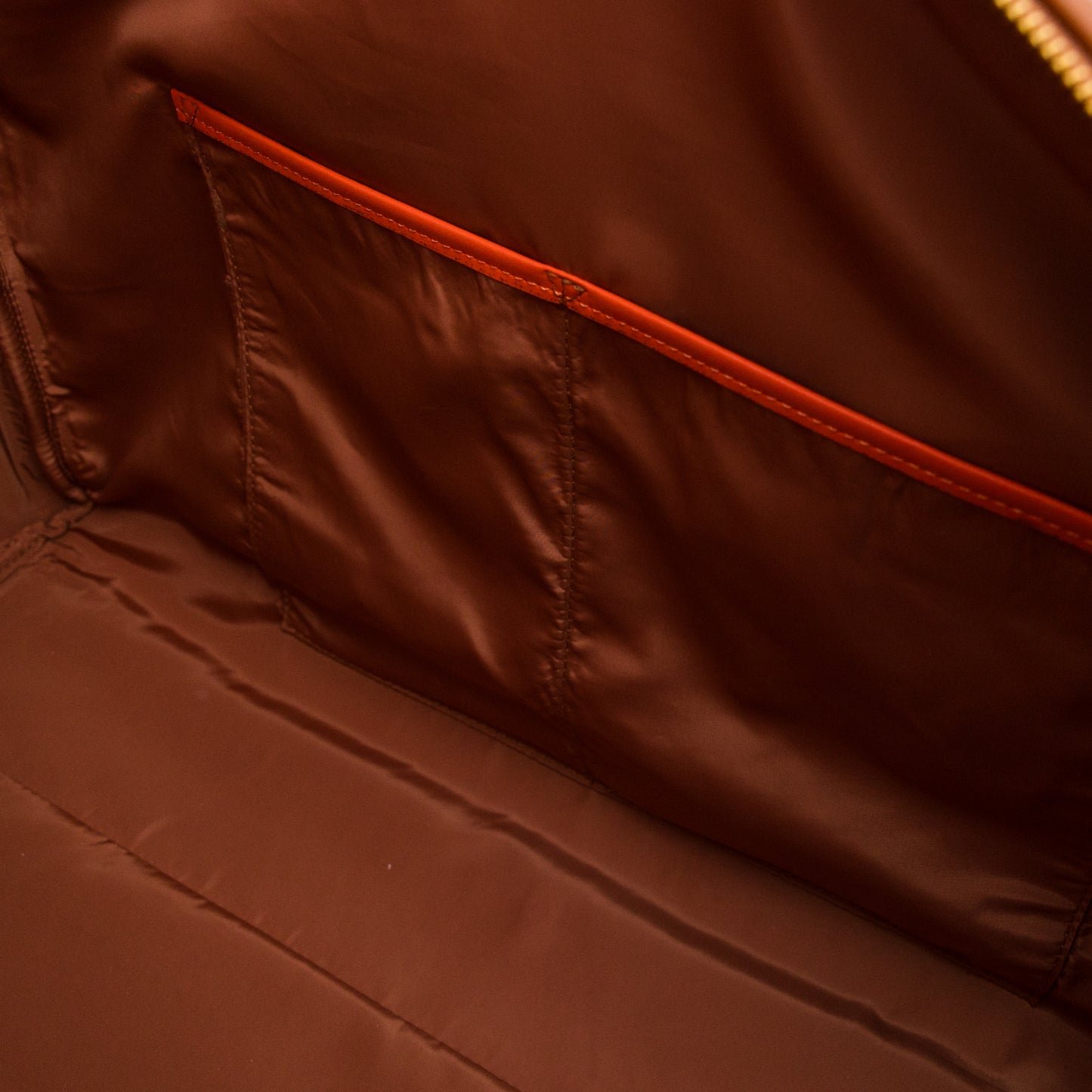 Close-up of a brown jacket with orange stitching detail