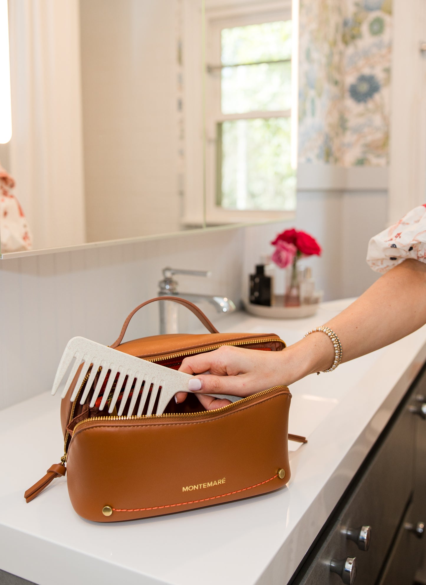 Brown toiletry case with hairbrush on a bathroom counter