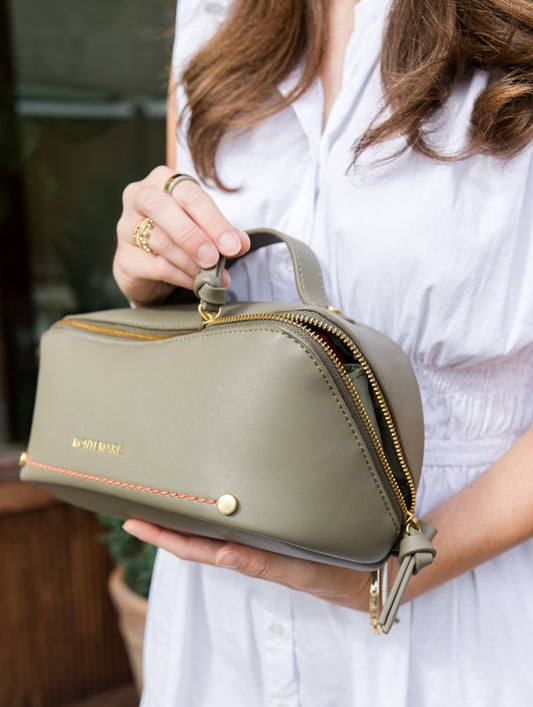 Person holding a green toiletry case with Montemare branding.