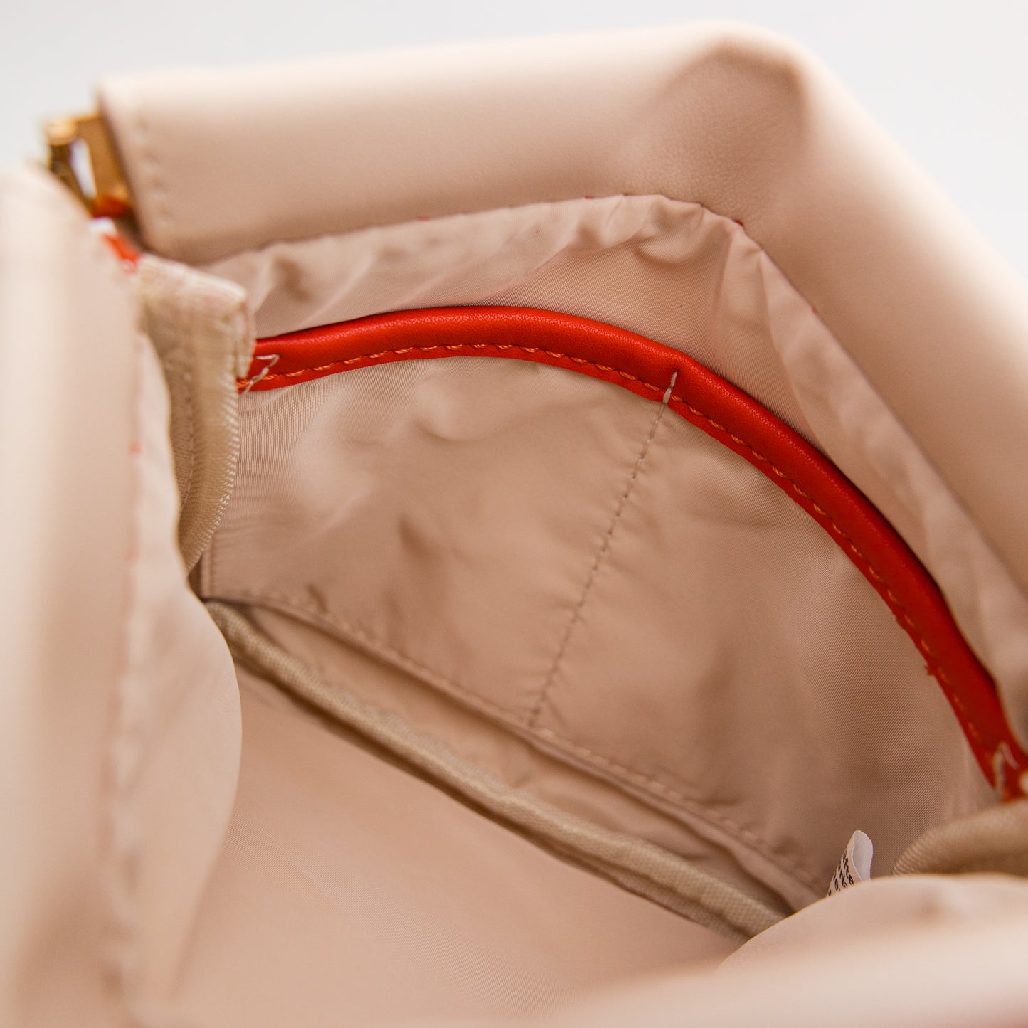 Close-up of beige fabric with orange accent