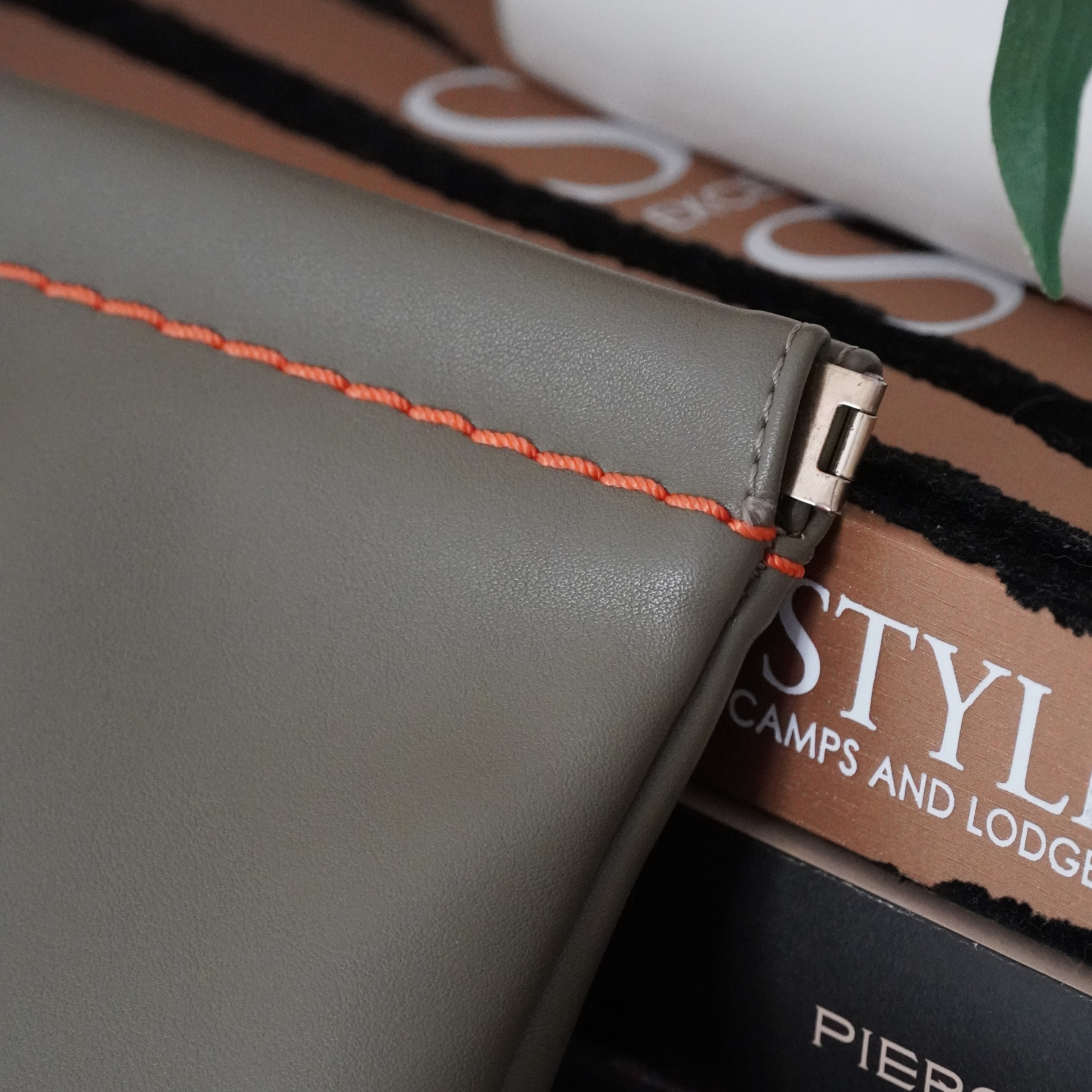Close up shot of Montemare Roma square pouch in olive with orange thread accent