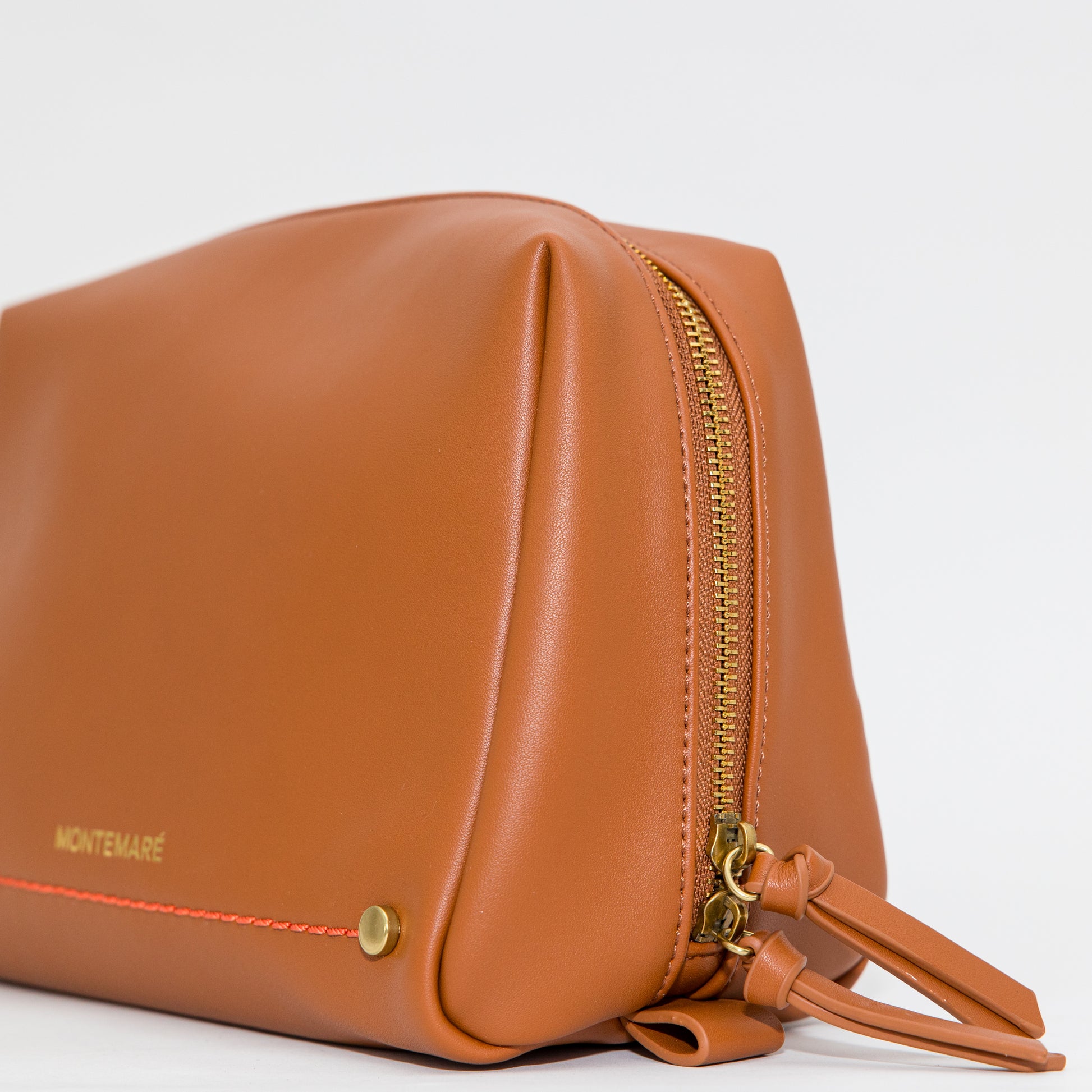 Brown leather pouch with gold zipper on a white background