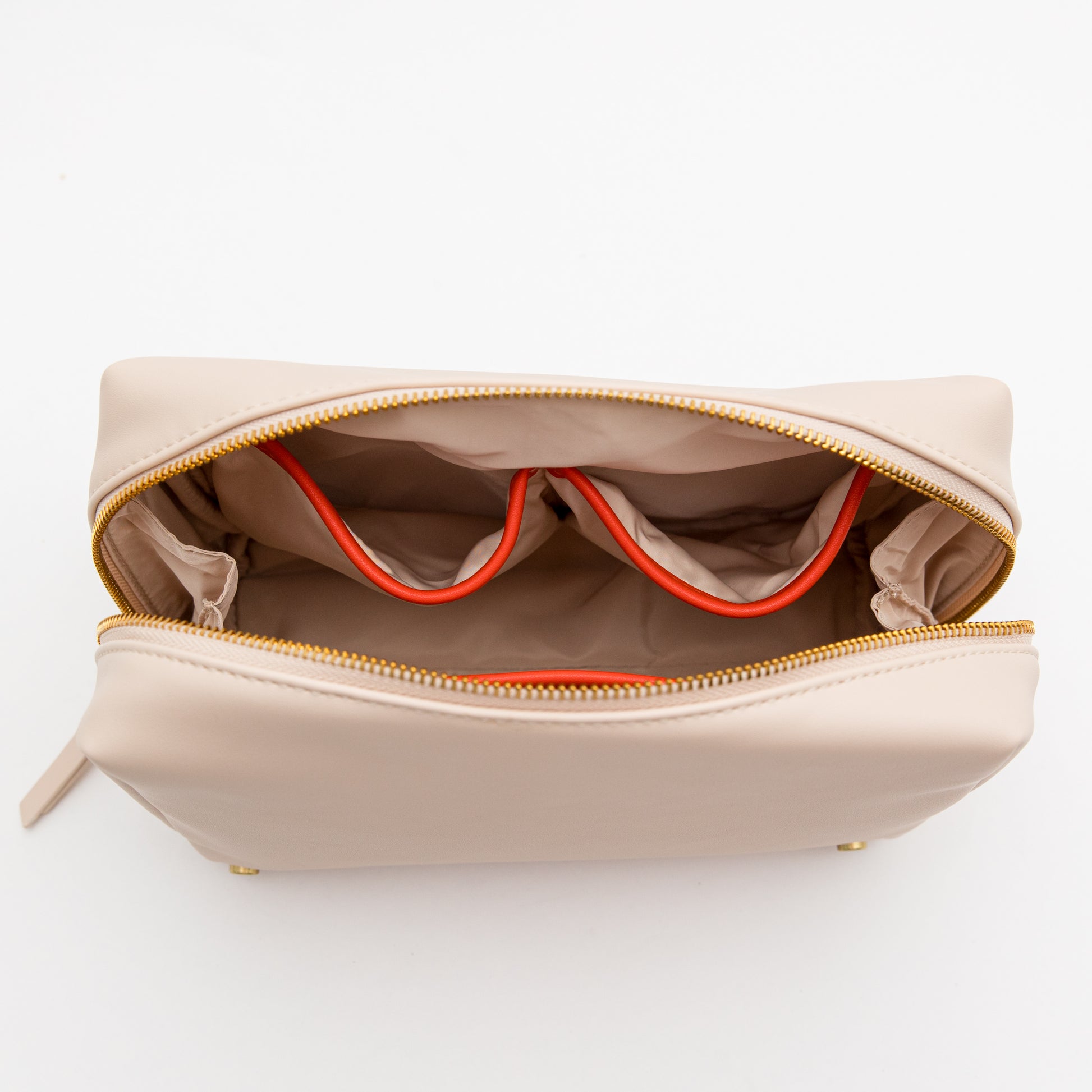 Beige toiletry bag with orange interior lining on a white background