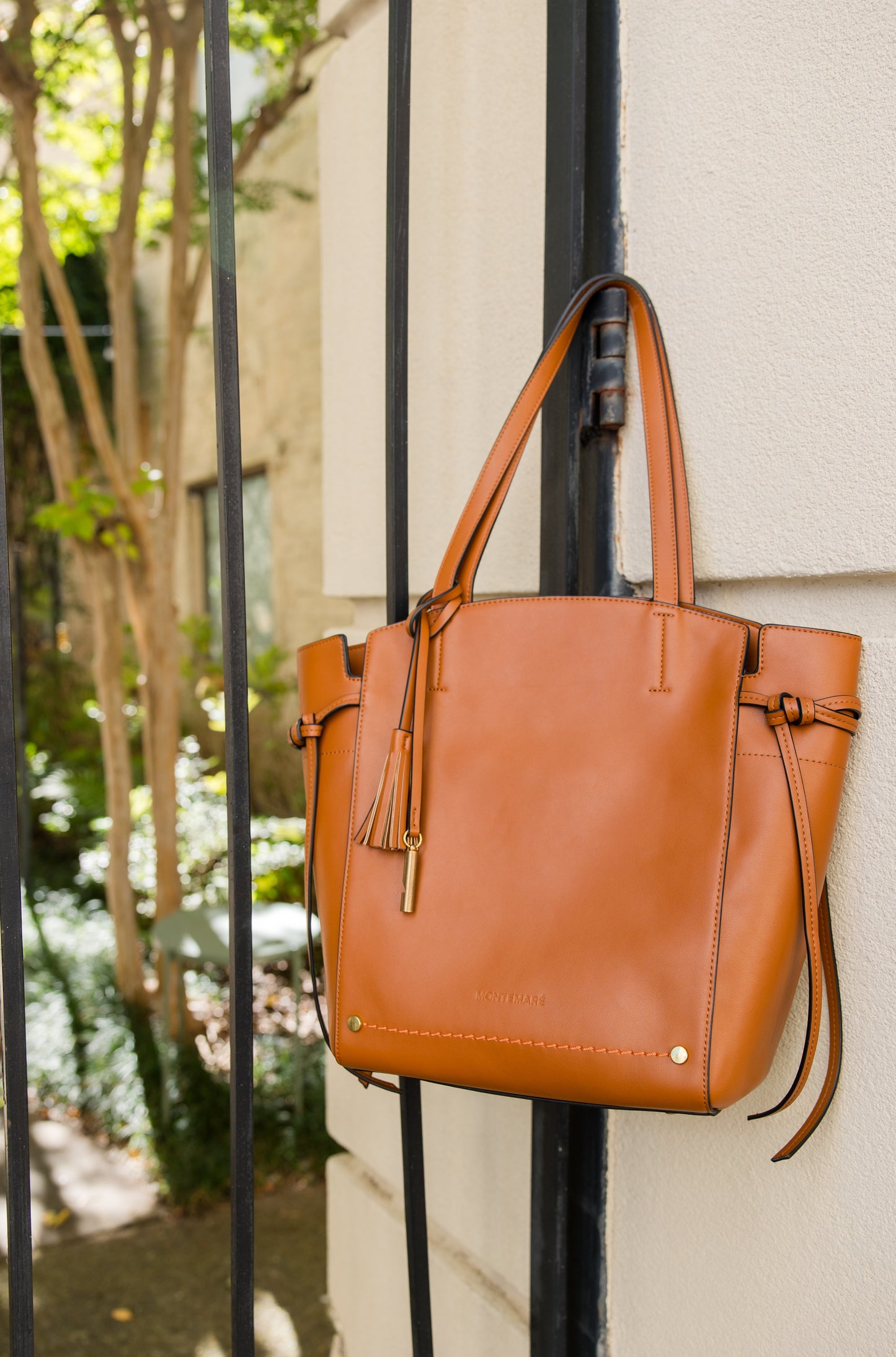Brown Tote hanging on fence post