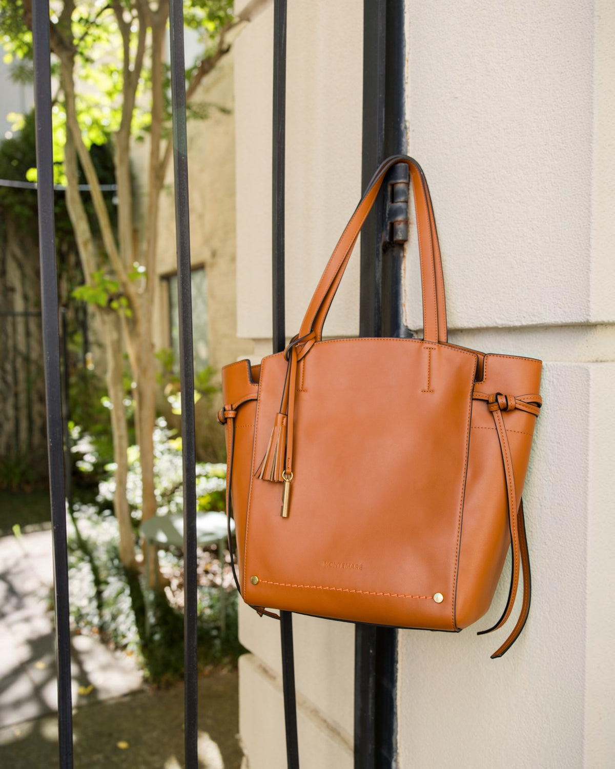 Brown Tote hanging on fence post