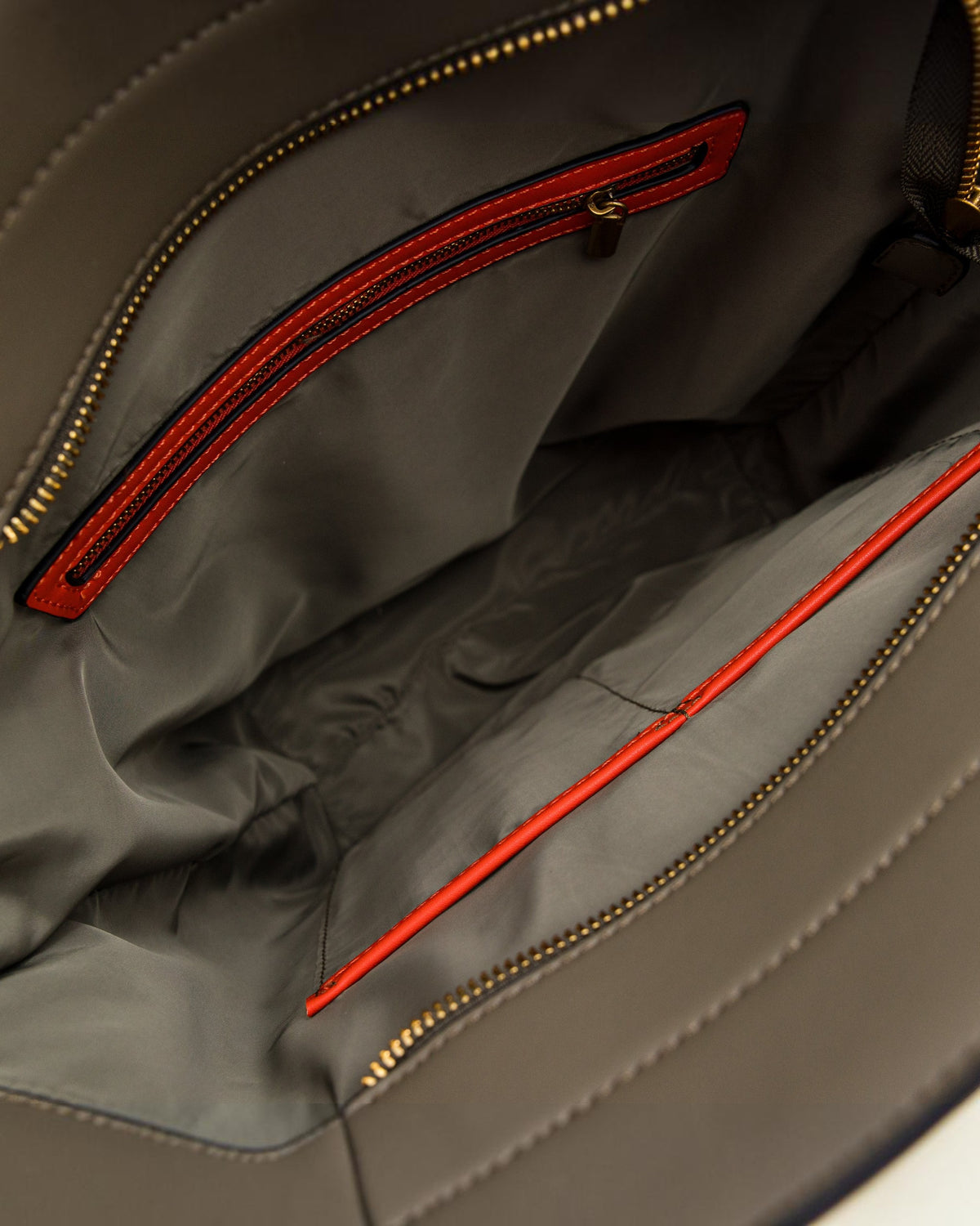 Close-up of an olive green tote bag with orange zipper details