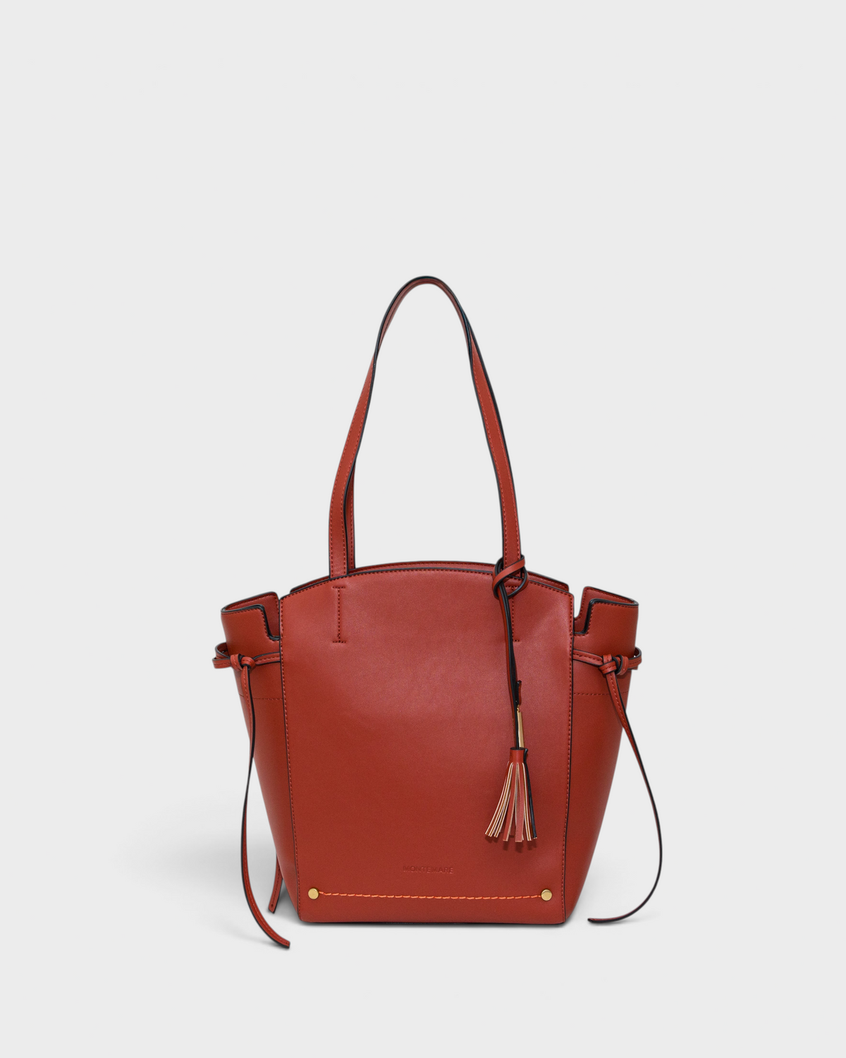 Terracotta leather handbag with a tassel on a white background