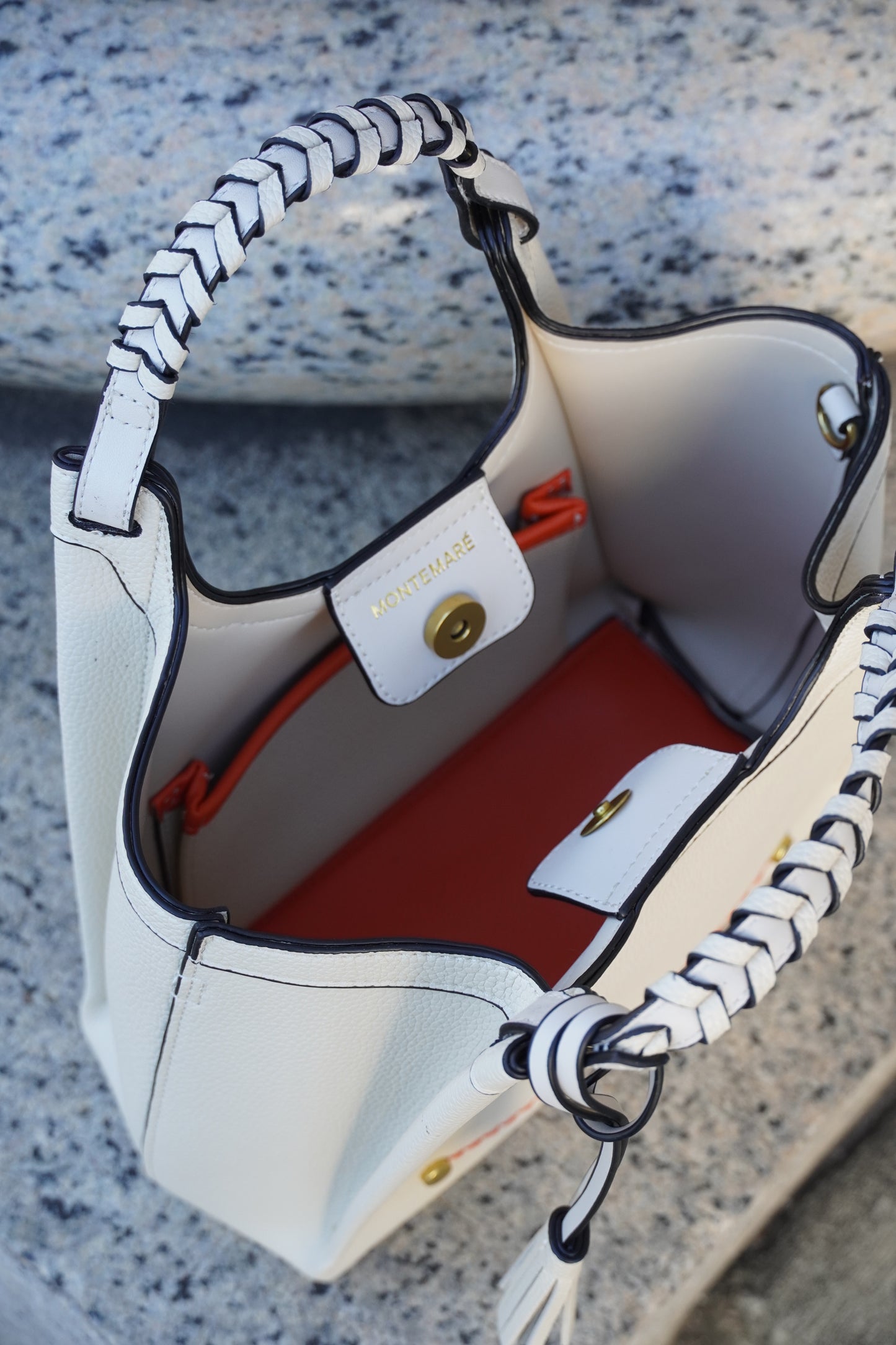 Interior of a Montemare Sedona Crossbody bag in ivory in a marble background