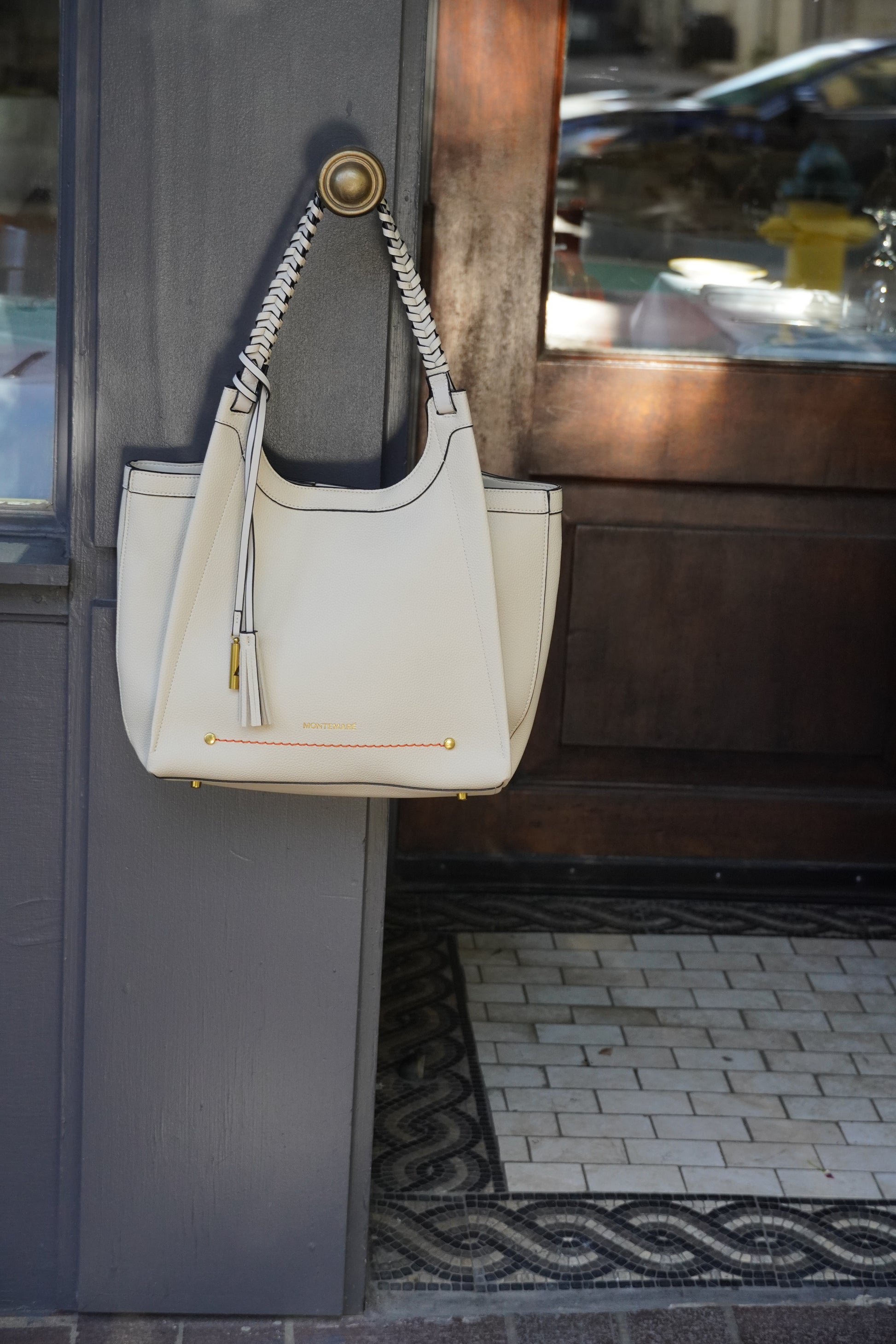 White handbag with styled strap on a dark surface