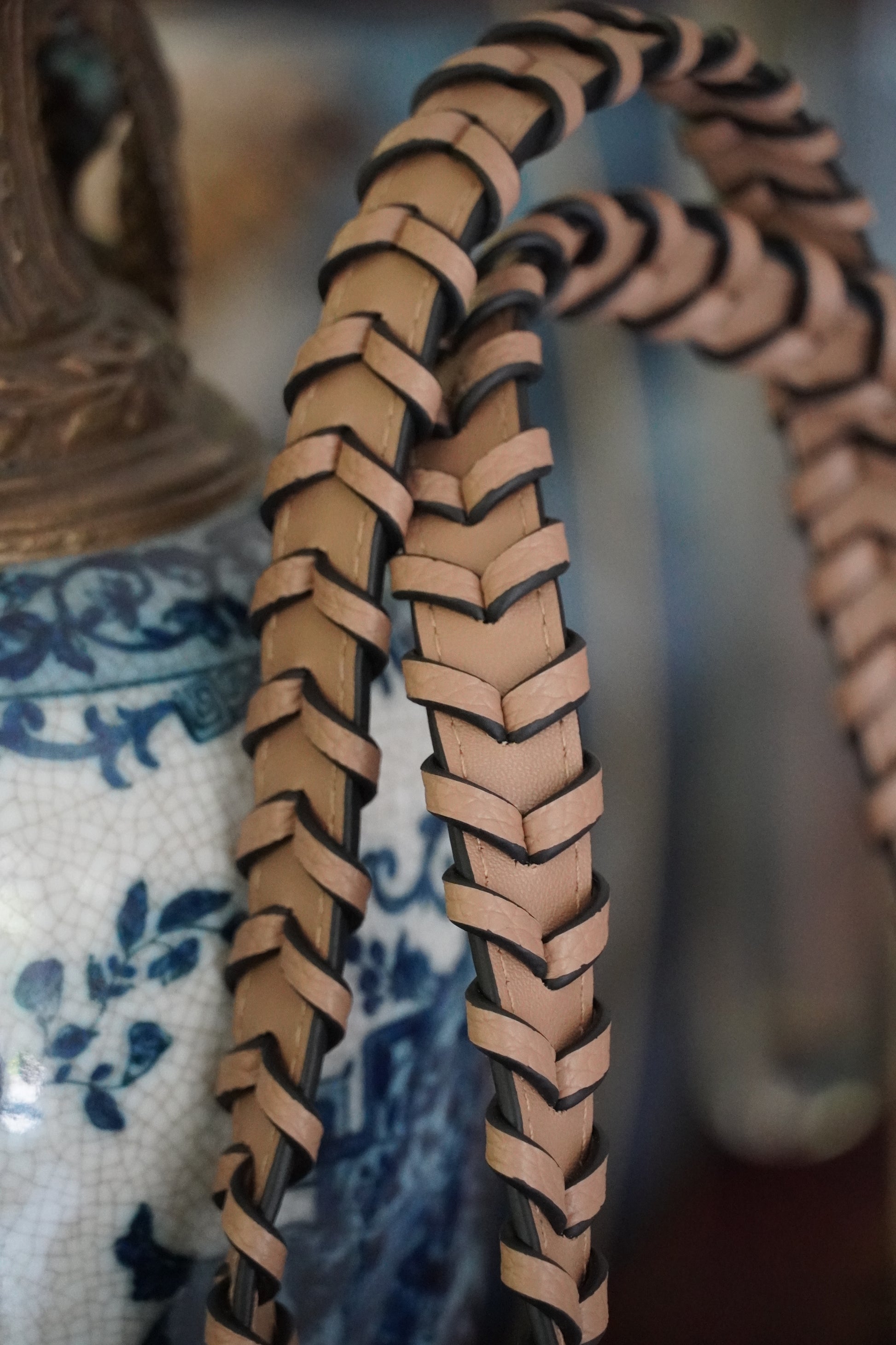 Close-up of woven leather strap on a patterned background