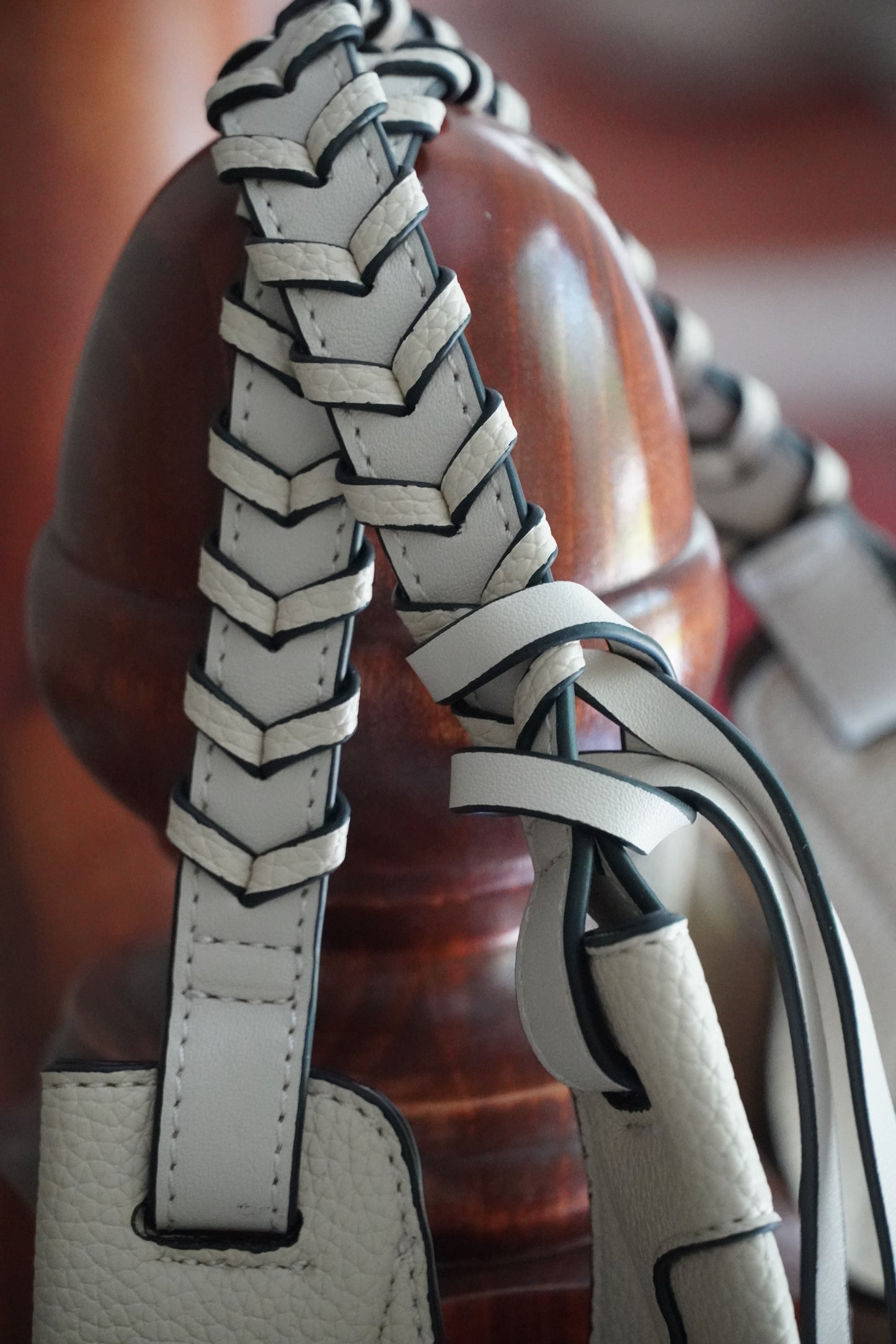 Close-up of a braided leather strap with a blurred background