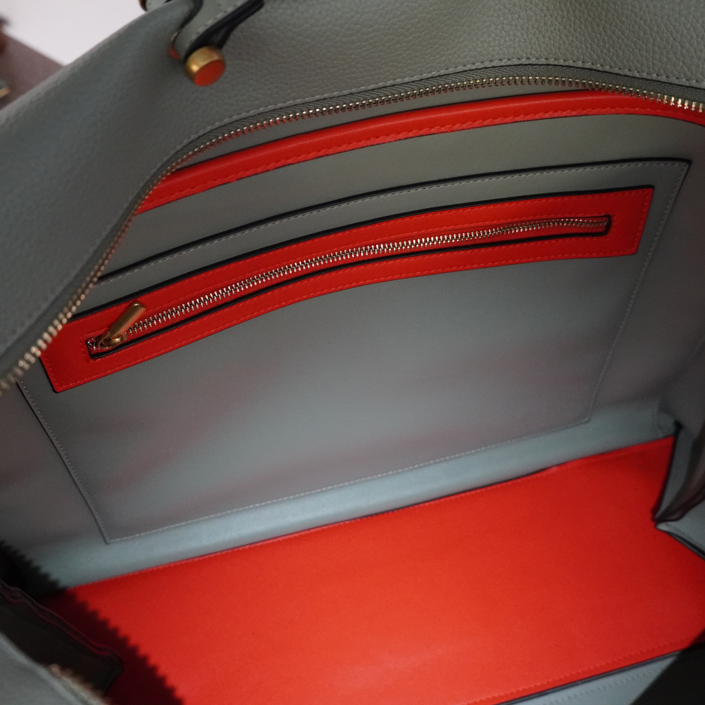 Close up shot of a light blue bag with orange interior linings