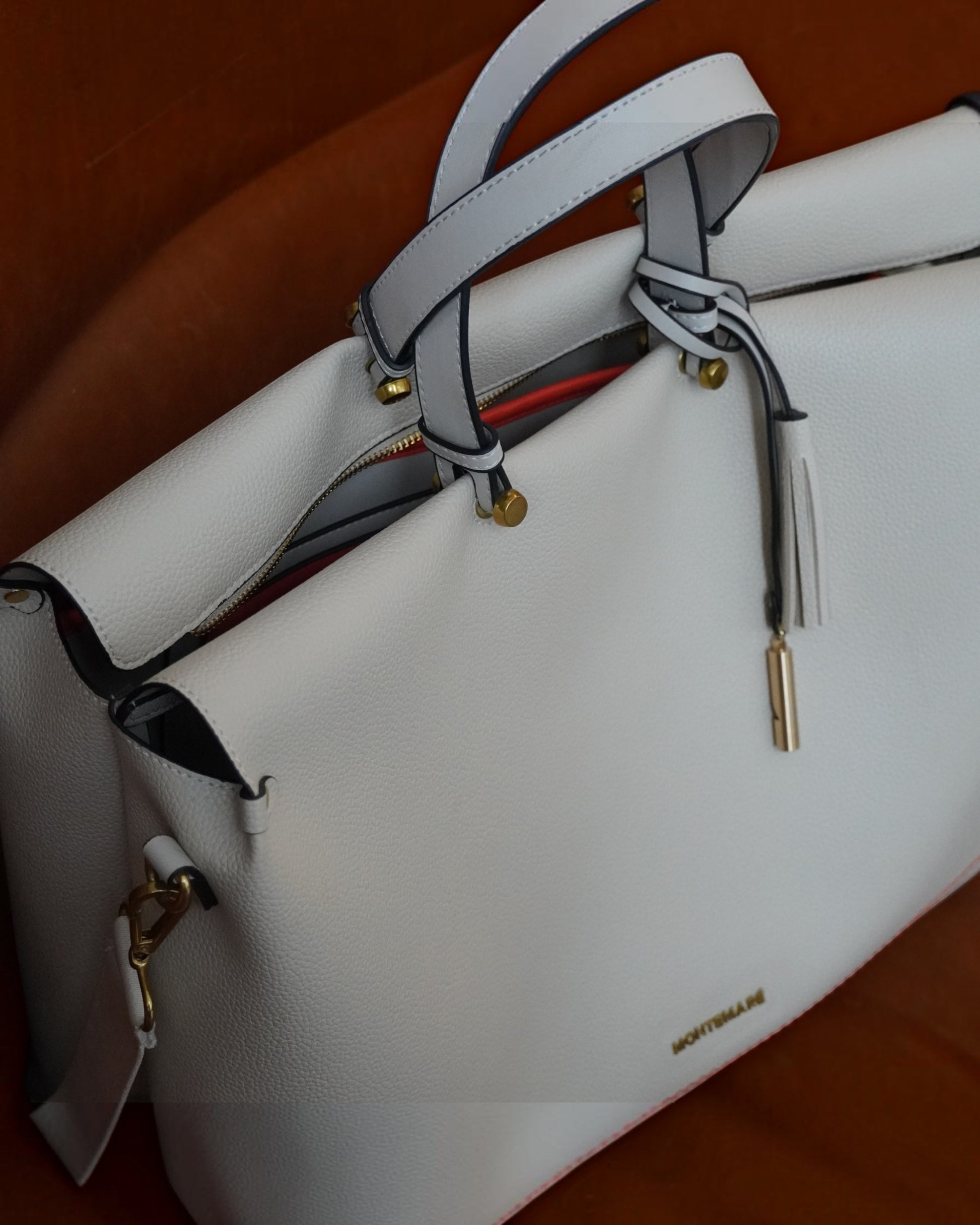 Detailed shot of Montemare Vienna Carry On Tote in ivory colorway on a brown background
