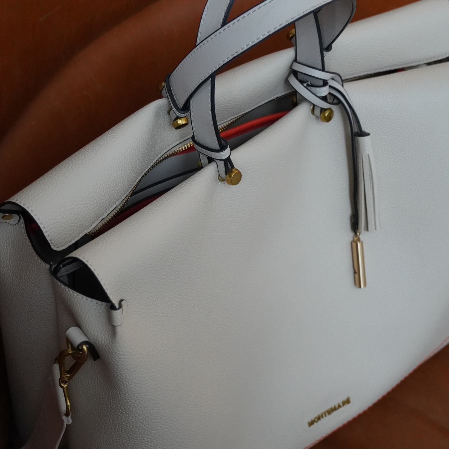 Detailed shot of Montemare Vienna Carry On Tote in ivory colorway on a brown background