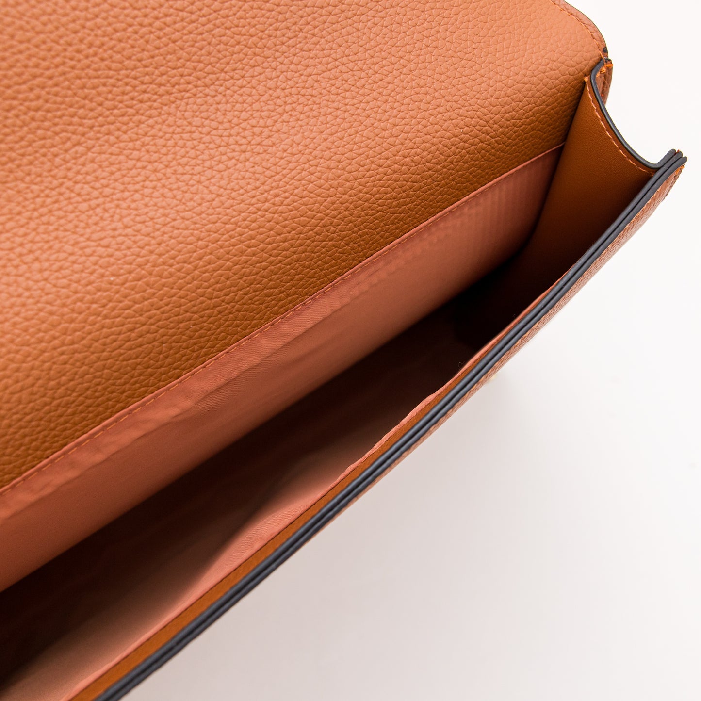 Close-up of a brown leather bag on a light background