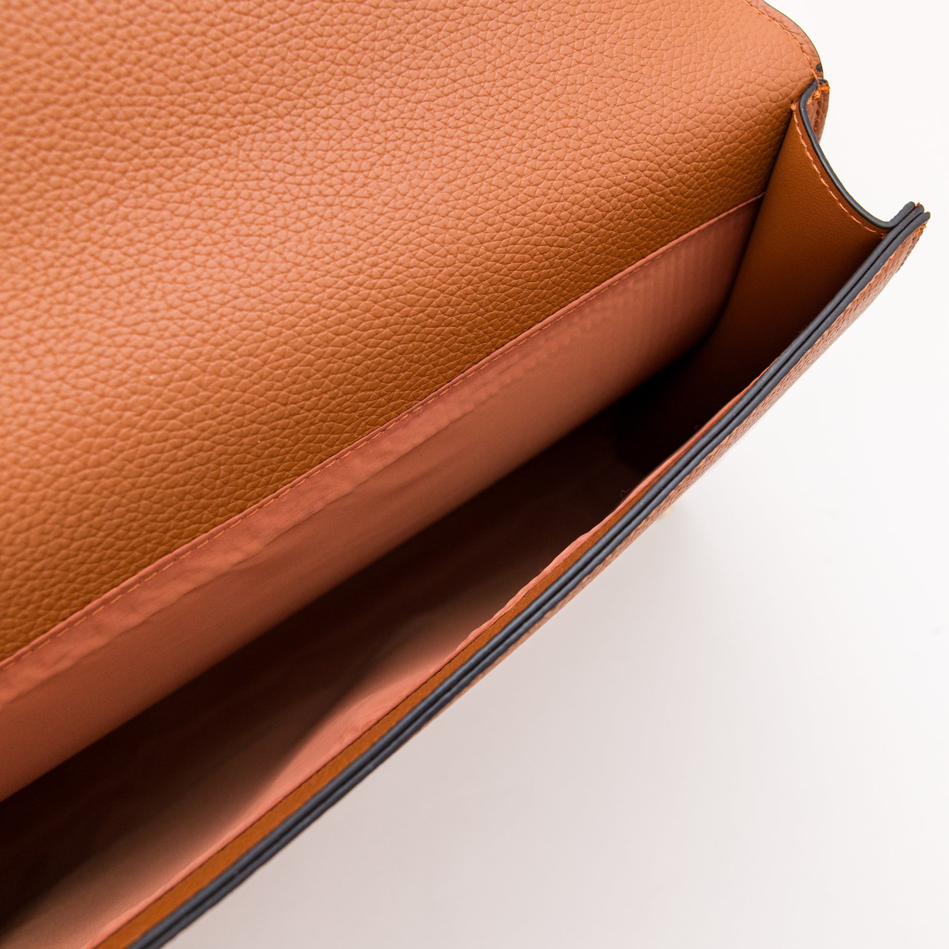 Close-up of a brown leather bag on a light background