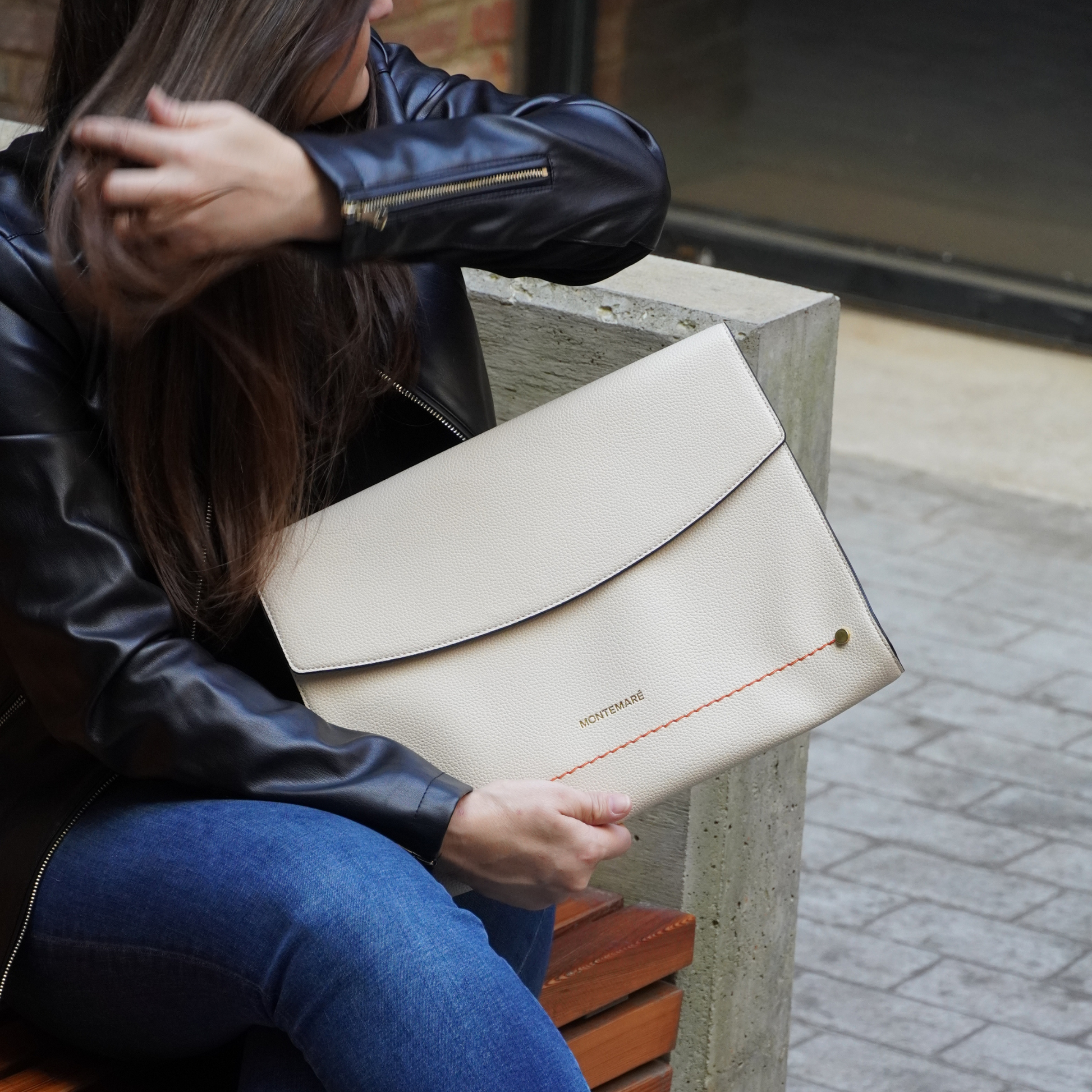 Woman holding a Montemare Vienna Laptop Case in Ivory on a street