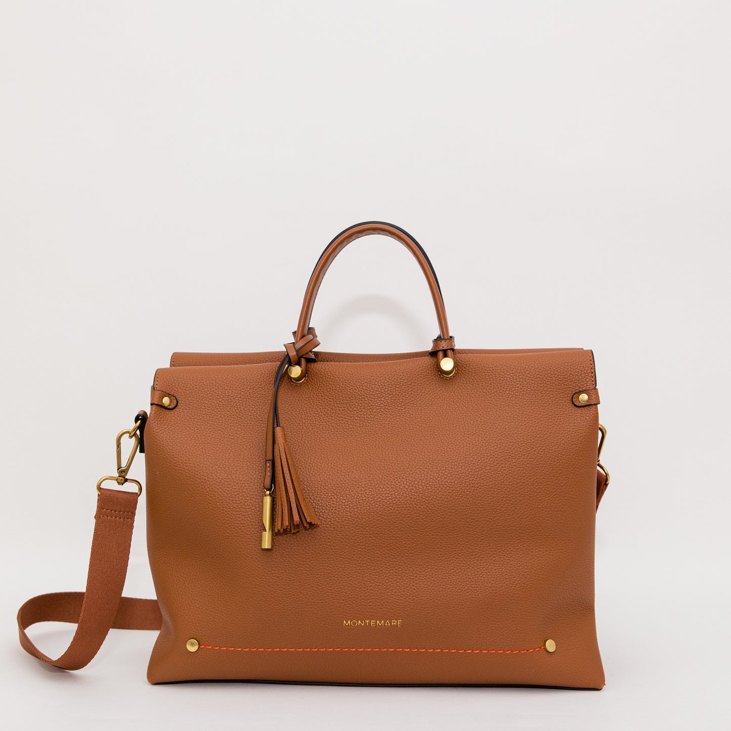 Cognac colored leather handbag with gold accents on a white background