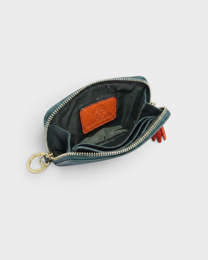Montemaré RFID-blocking vegan leather card case in green with interior card slots, gold zipper, and orange tassel.