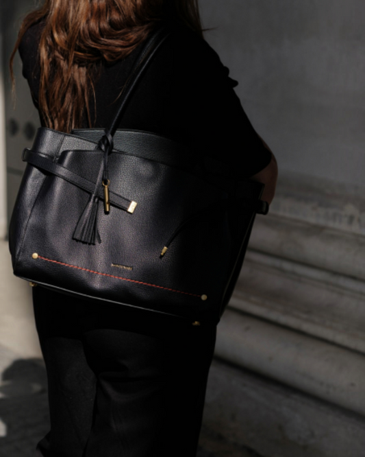 Montemaré Mayfair black pebbled vegan leather work tote with a safety whistle tassel worn over the shoulder.