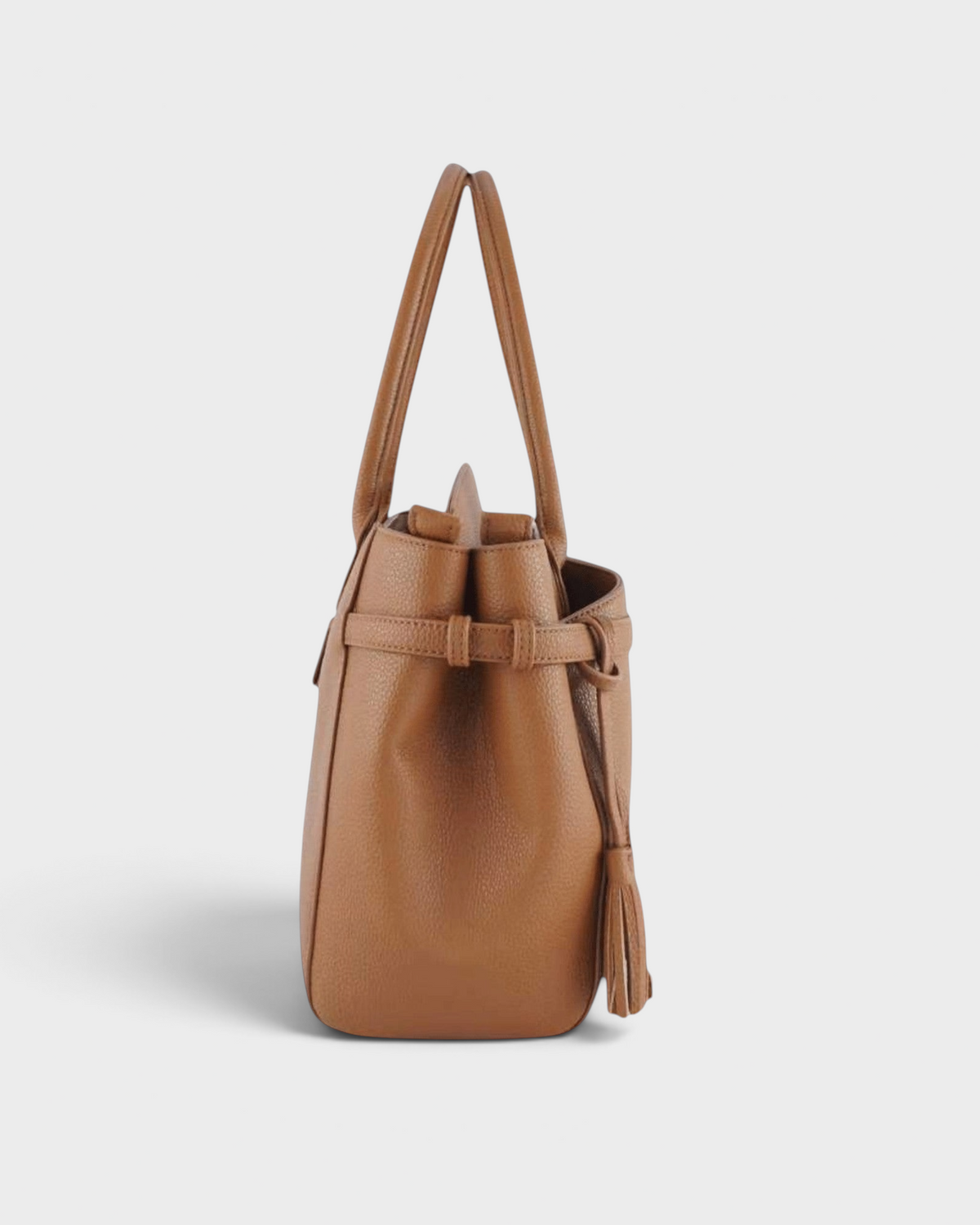 Side view of a tan Montemaré Mayfair work tote bag in pebbled leather with a decorative tassel and side strap detail.