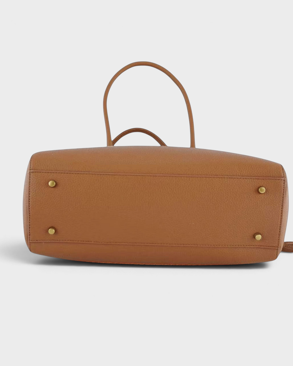 Bottom view of a tan pebbled leather Montemaré Mayfair work tote featuring four protective gold-tone metal feet.