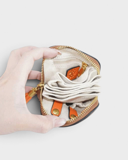 Montemaré small travel jewelry case in orange and brown leather with a beige fabric interior and gold zipper