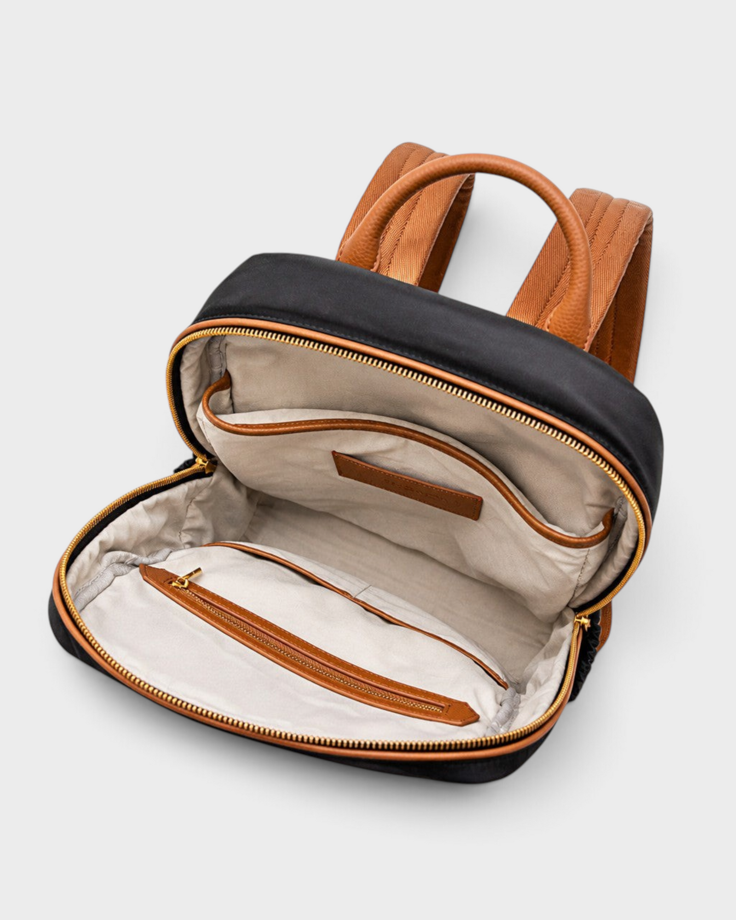 Montemaré Oslo backpack interior with beige cotton lining, leather trim, and zippered pockets on a white background.