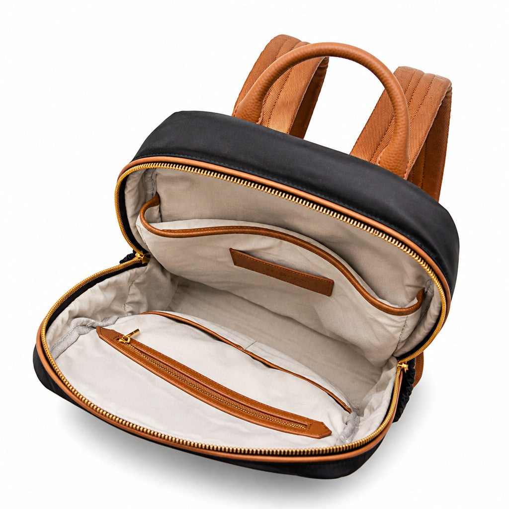 Montemaré Oslo backpack in black nylon and tan leather with an open main compartment showing a light cotton interior.