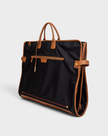Montemaré Oslo tri-fold garment bag in black waterproof nylon with tan leather trim and gold hardware.