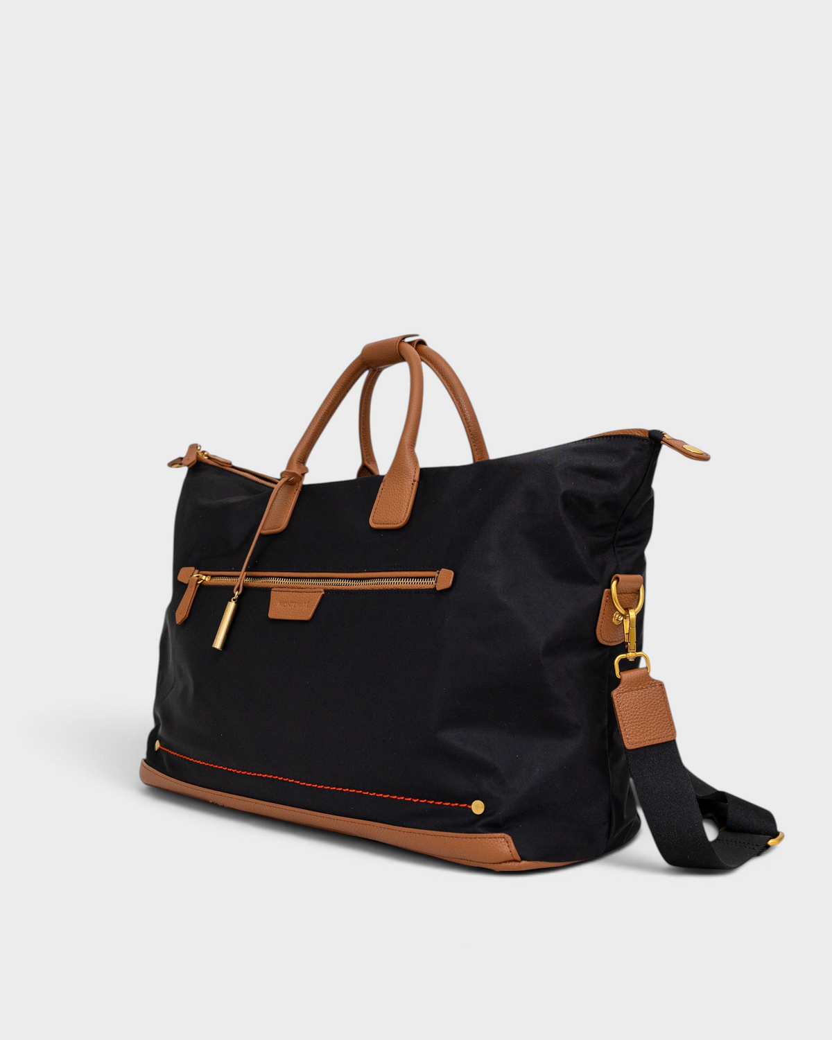 Montemaré Oslo black waterproof nylon weekender bag with tan leather trim, gold hardware, and shoulder strap.