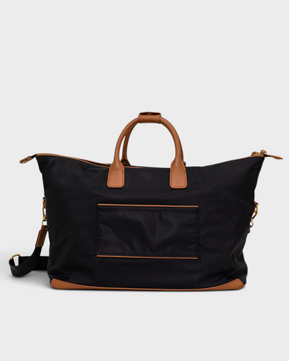 Montemaré Oslo black waterproof nylon weekender bag with tan leather handles and trim on a white background.