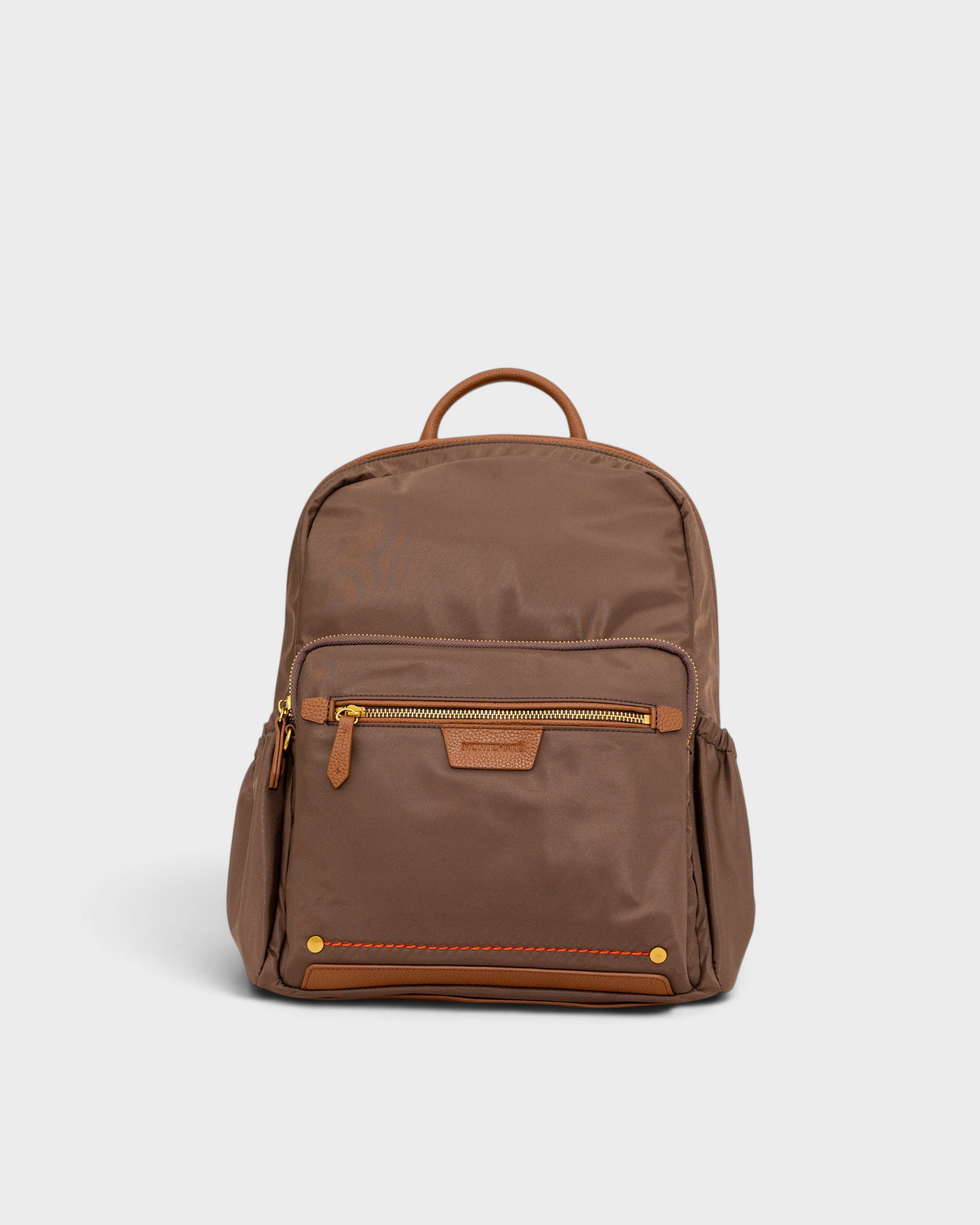 Montemaré Oslo premium brown nylon and leather backpack with gold zippers and front pocket on a light grey background