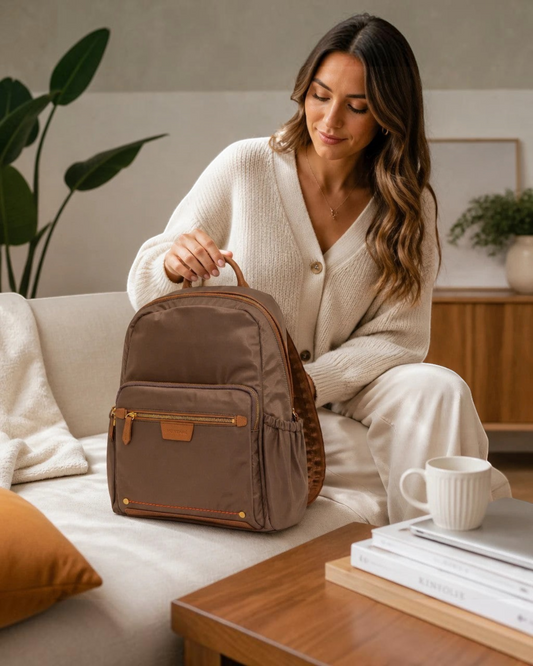 Montemaré Oslo brown nylon and leather RFID-blocking backpack on a sofa with a woman in a cozy cream cardigan