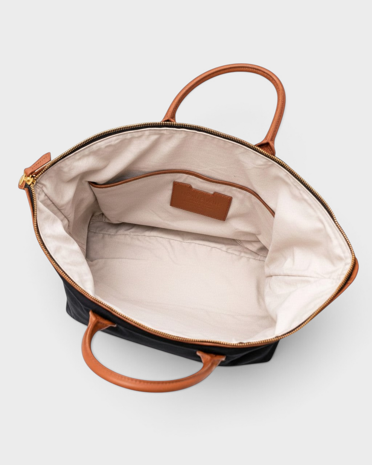 Montemaré Oslo carry-on bag interior with cream cotton lining, leather trim, and open pockets on a white background
