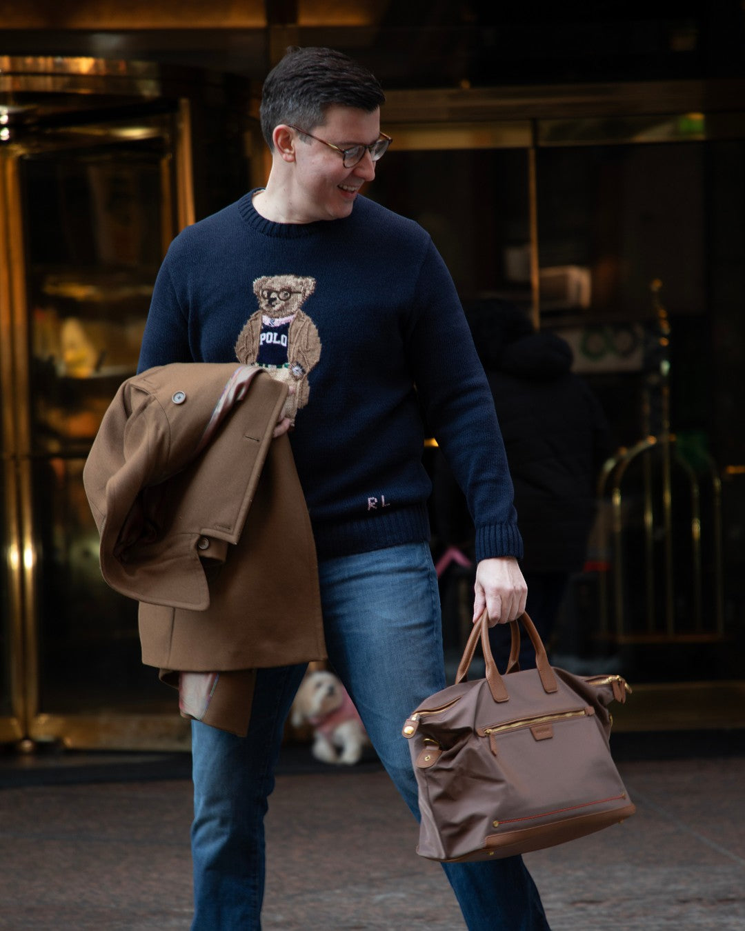 Man carrying a Montemaré Oslo Carry-On brown waterproof nylon weekender bag with leather accents in a city setting