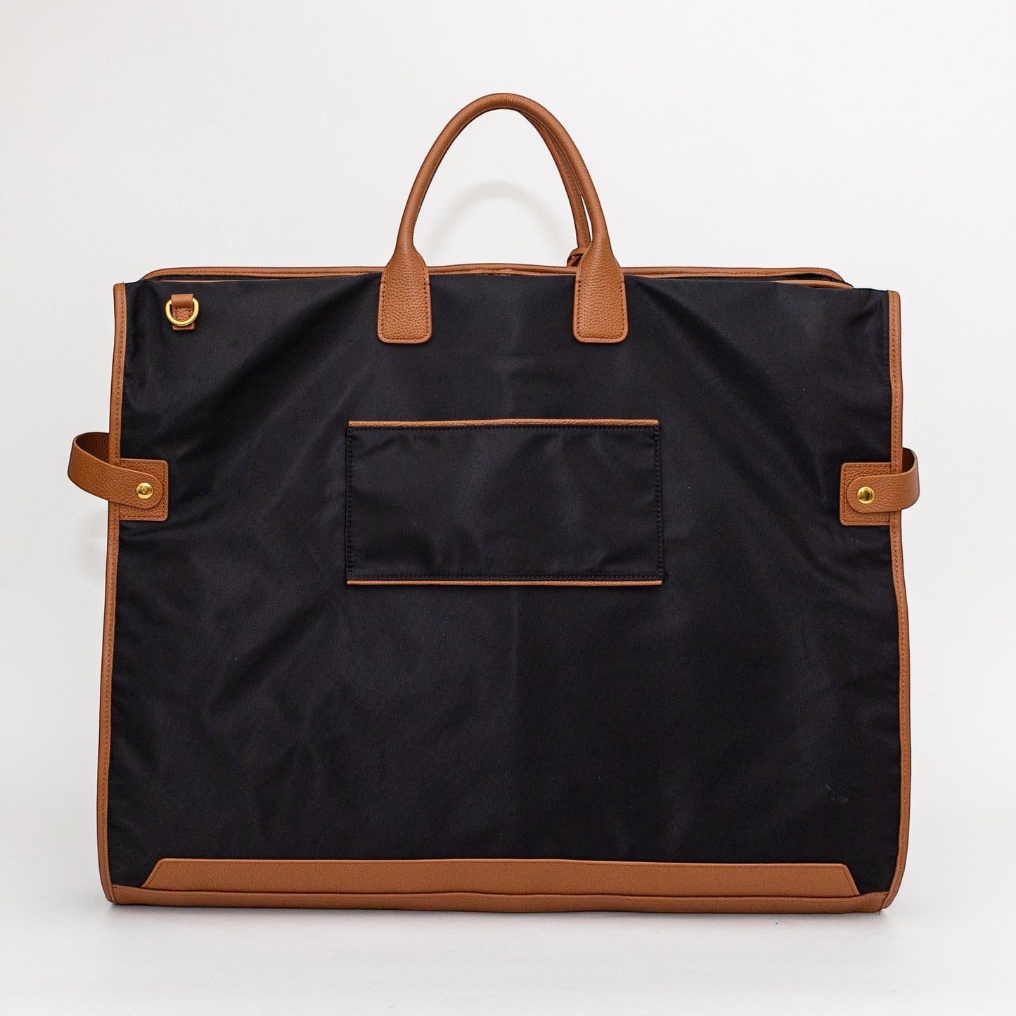 Montemaré Oslo garment bag in black waterproof nylon with tan leather trim, featuring top handles and side straps.