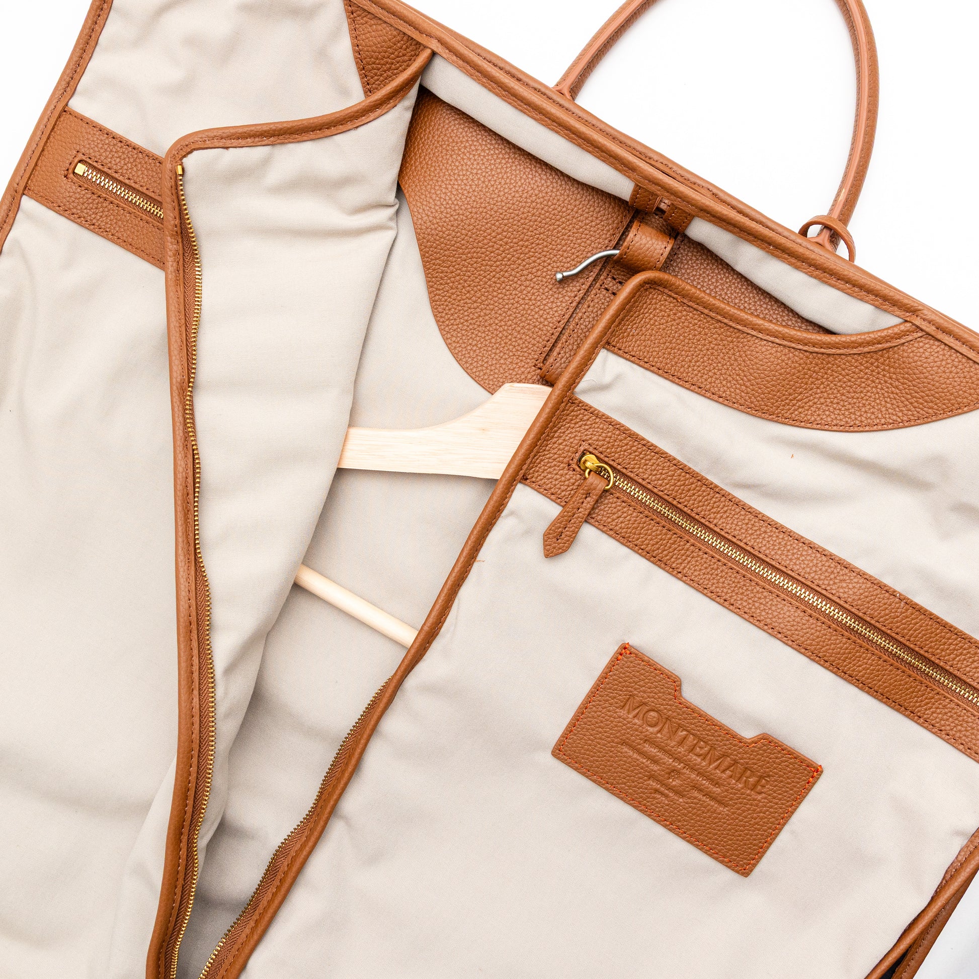 Close-up of a beige and brown bag with a visible brand logo on a light background
