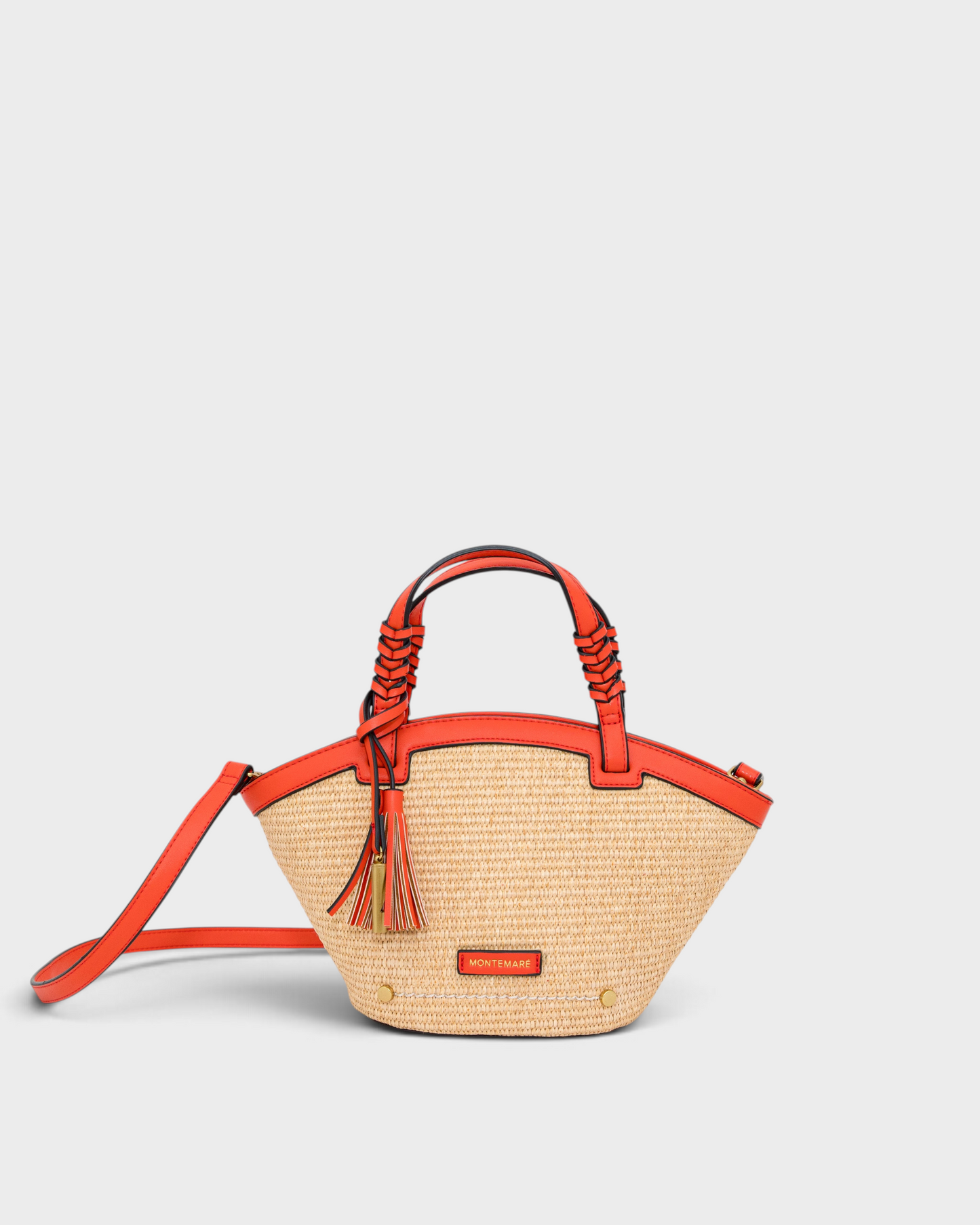 Montemaré Palma Crossbody bag in straw-like material with orange vegan leather trim, top handles, and tassel detail.