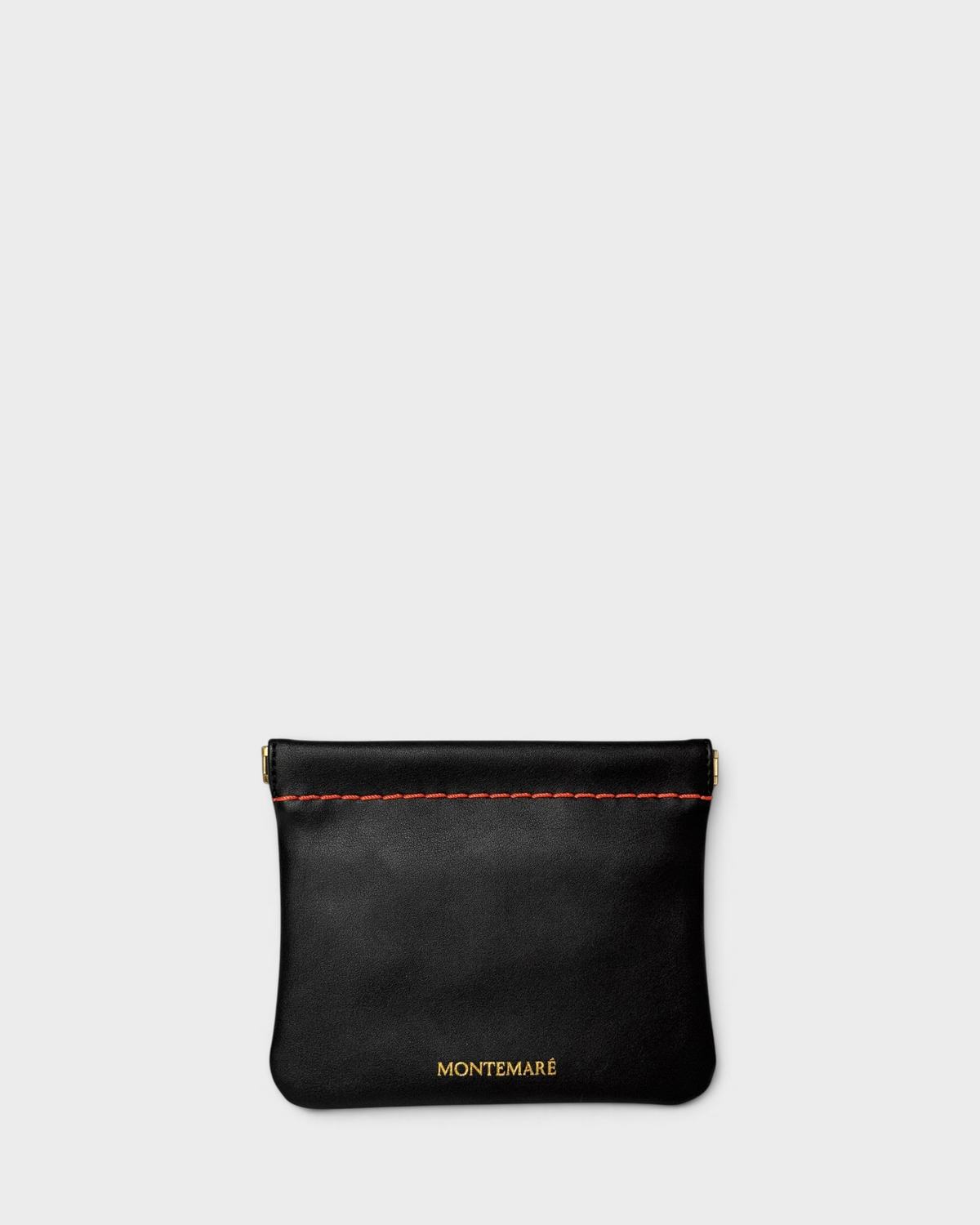 Montemaré Roma square pouch in black vegan leather with orange contrast stitching and a secure spring-frame closure.