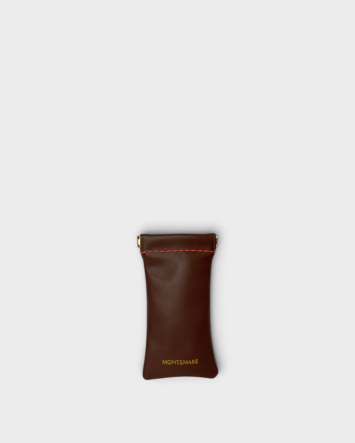 Montemaré Roma brown vegan leather sunglasses case with a spring-frame closure and red stitching detail.