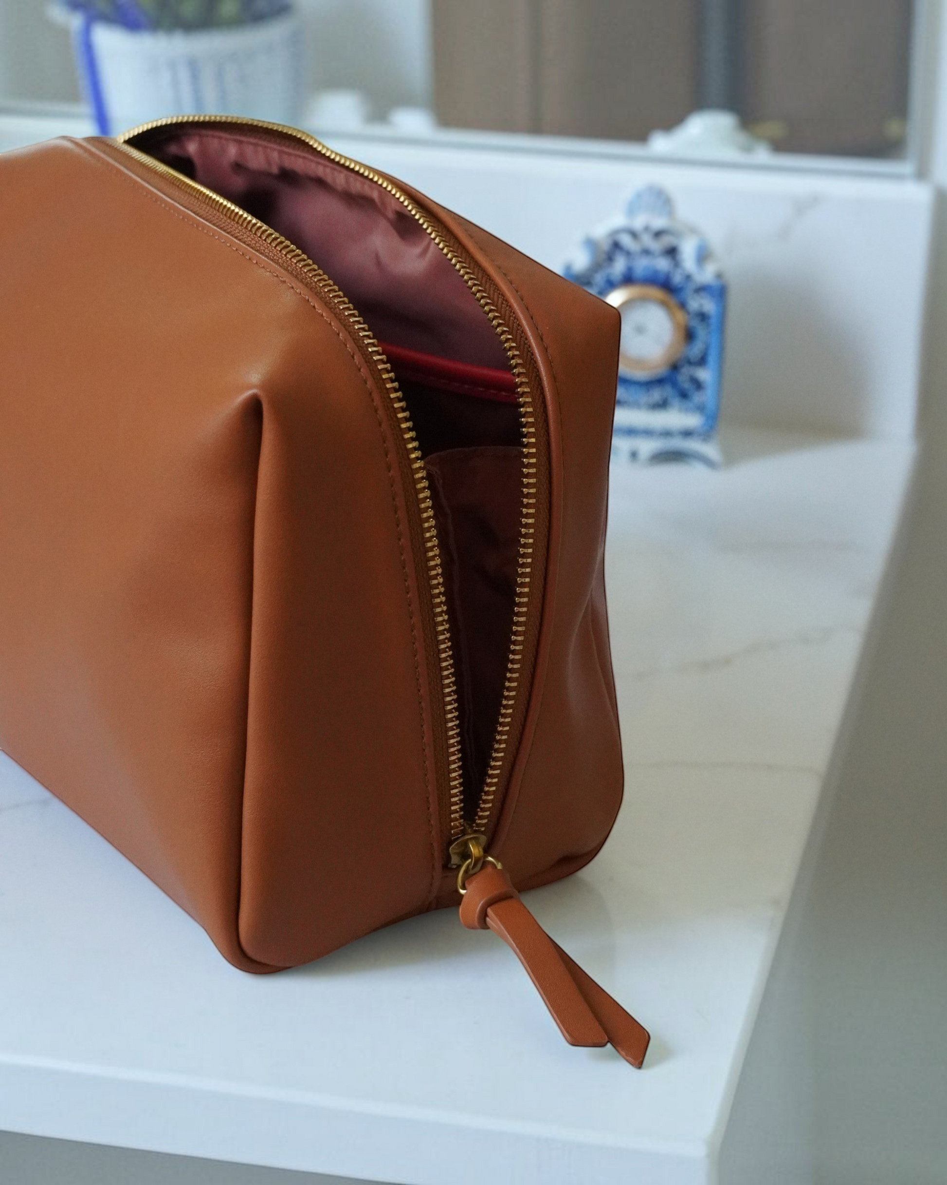 Montemaré Roma standing toiletry case in brown vegan leather with a wide zipper opening and orange interior accents