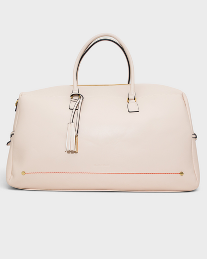 Montemaré Roma Duffel in cream vegan leather with gold hardware, tassel detail, and orange stitching accents.